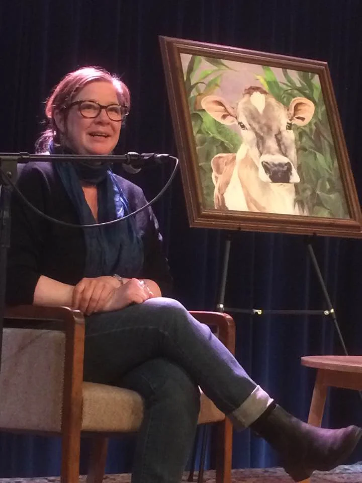 me speaking, with a glamorous painting of a cow for company on stage!