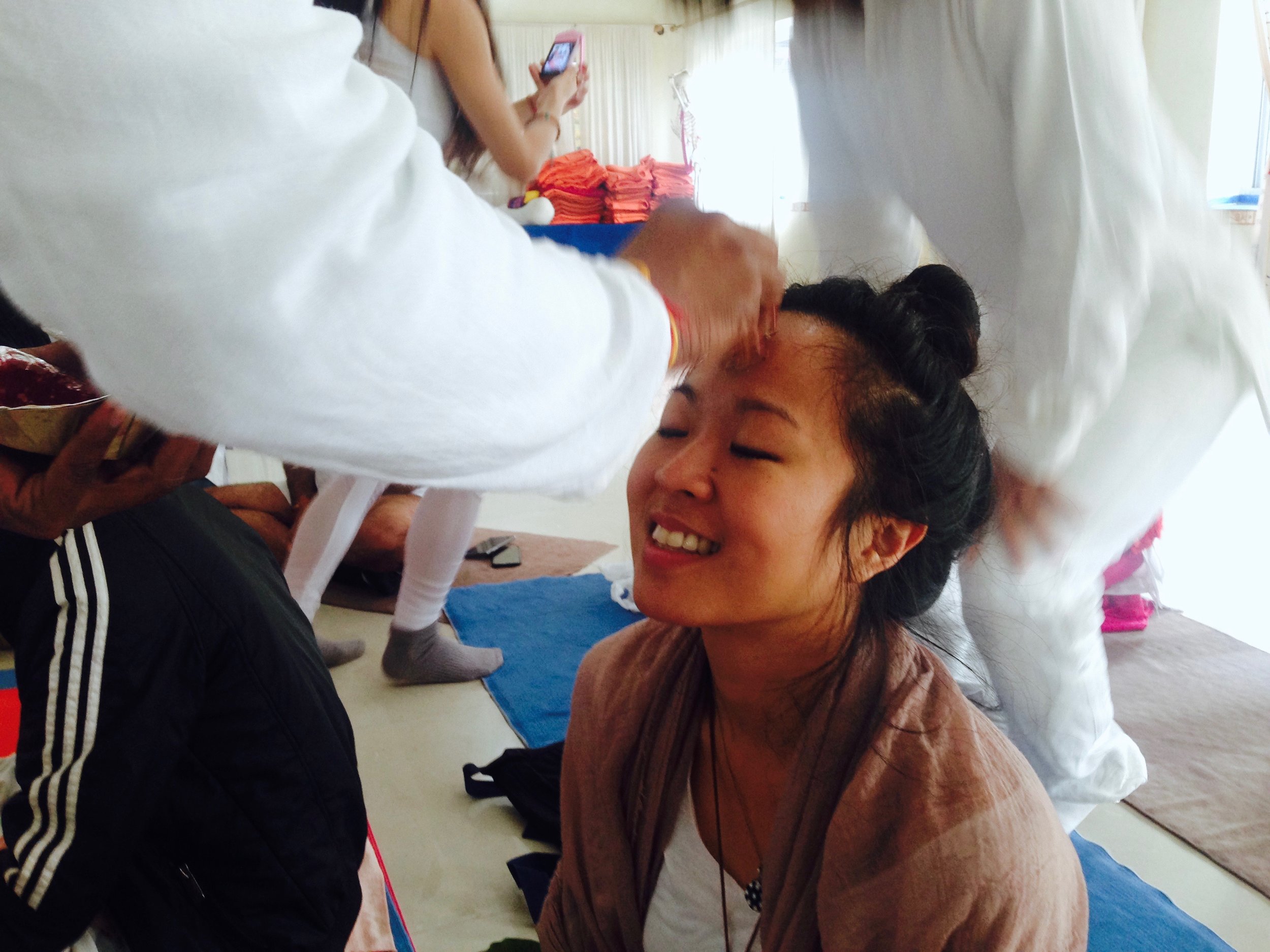 Receiving a tilak over my third eye, made of flower powder and water