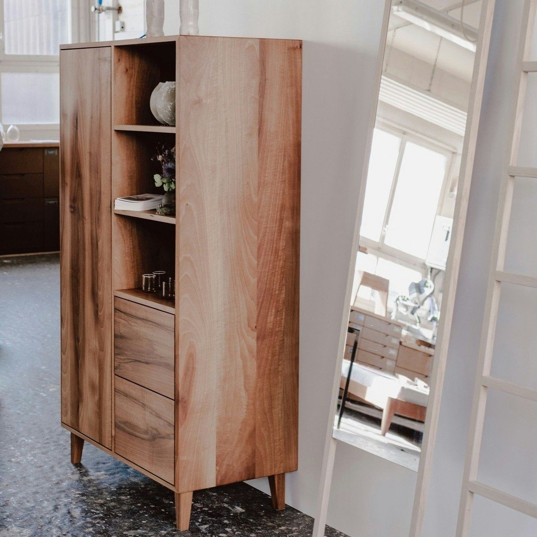 Highboard Marek aus unserer Kollektion in unged&auml;mpften franz&ouml;sischen Nussbaum. Daneben ein Massgefertigter Spiegel aus Hellem Escheholz und ein dazu passendes clothes rack.