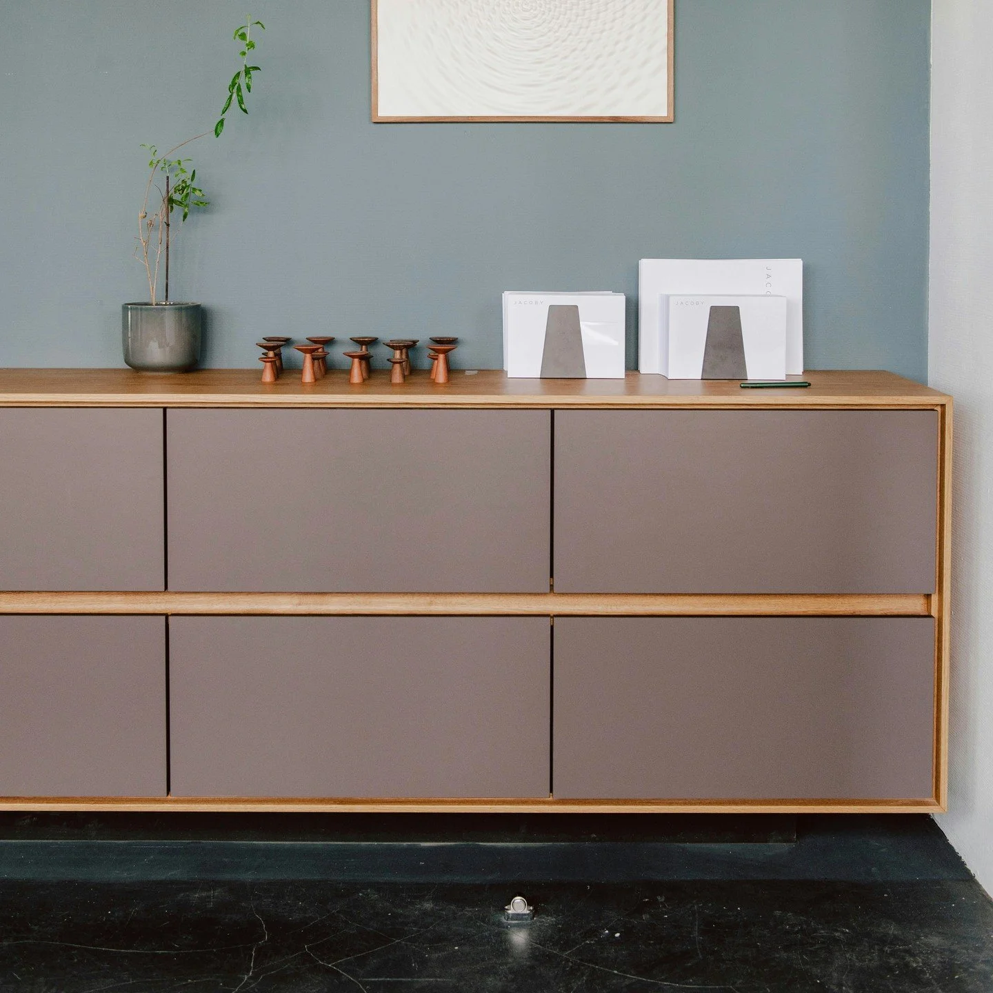 Massgefertigtes M&ouml;bel, umrahmt von massiver Eiche und mit Fronten aus Linoleum. Der zur&uuml;ckversetzte Sockel verleiht dem M&ouml;belst&uuml;ck eine schwebende Optik. Linoleum ist in einer Vielzahl wundersch&ouml;ner Farbvarianten erh&auml;ltl