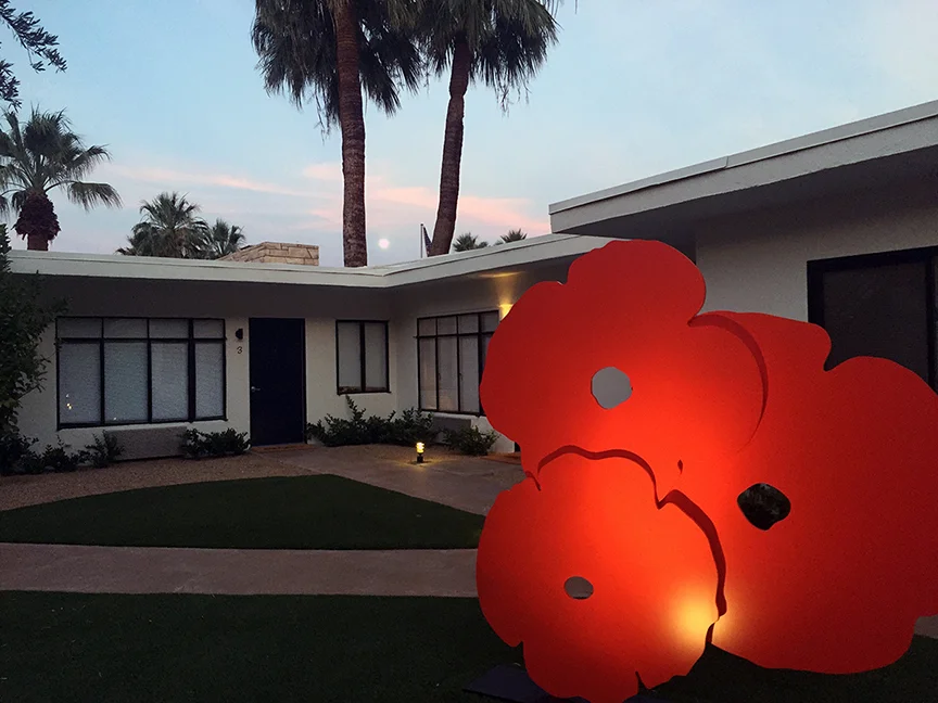 Outdoor sculpture and full moon peeking out at Holiday House.