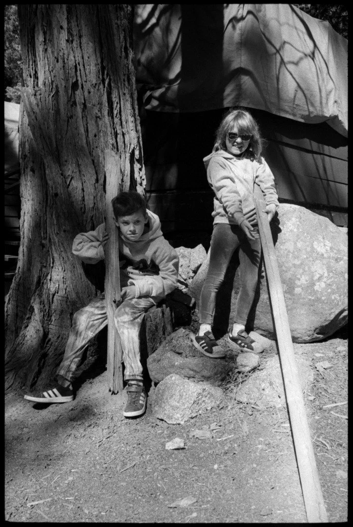 a black and white photograph of two children at the lair of the golden bear in california