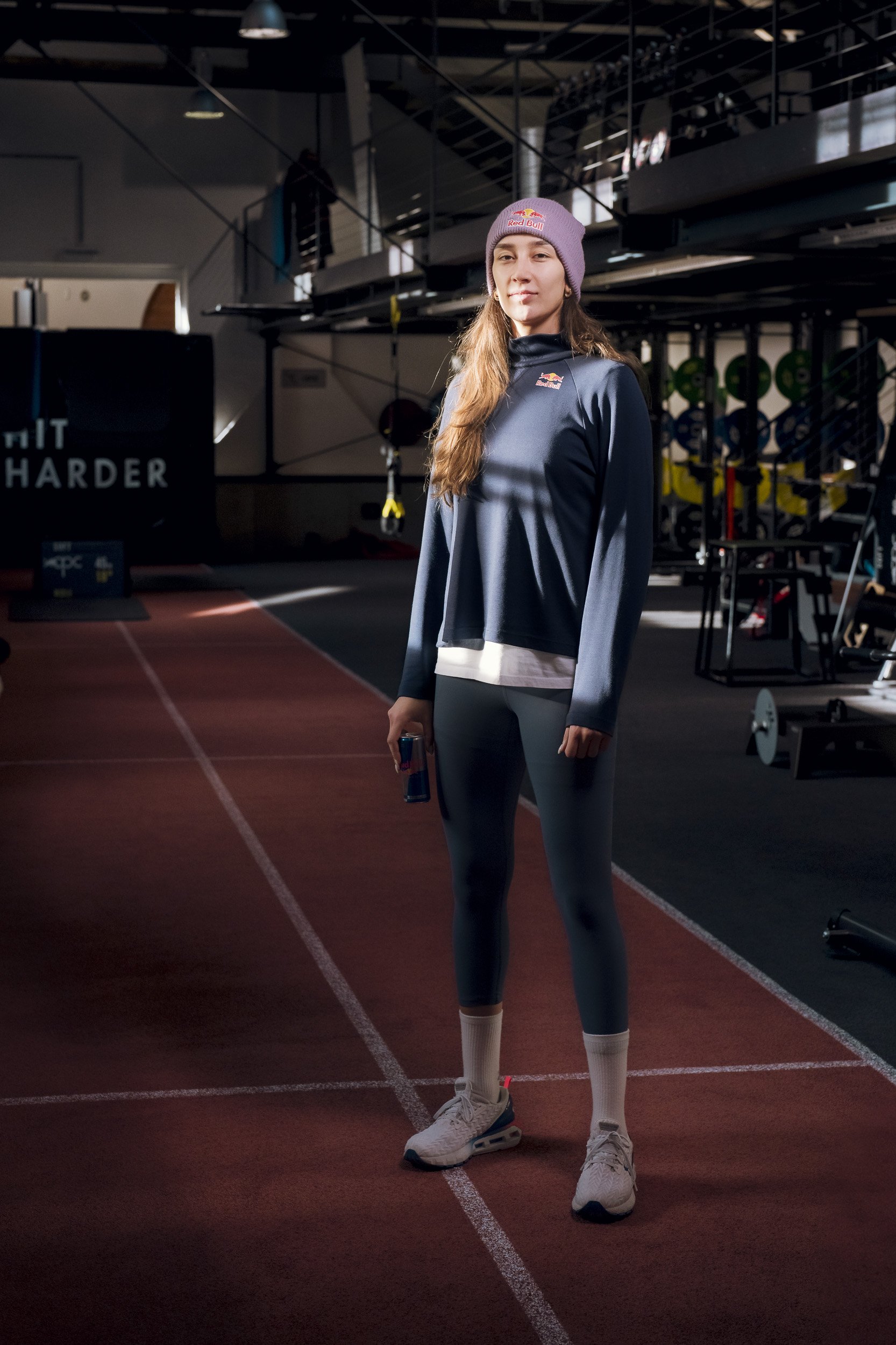 Young woman in athletic gear standing in a gym.