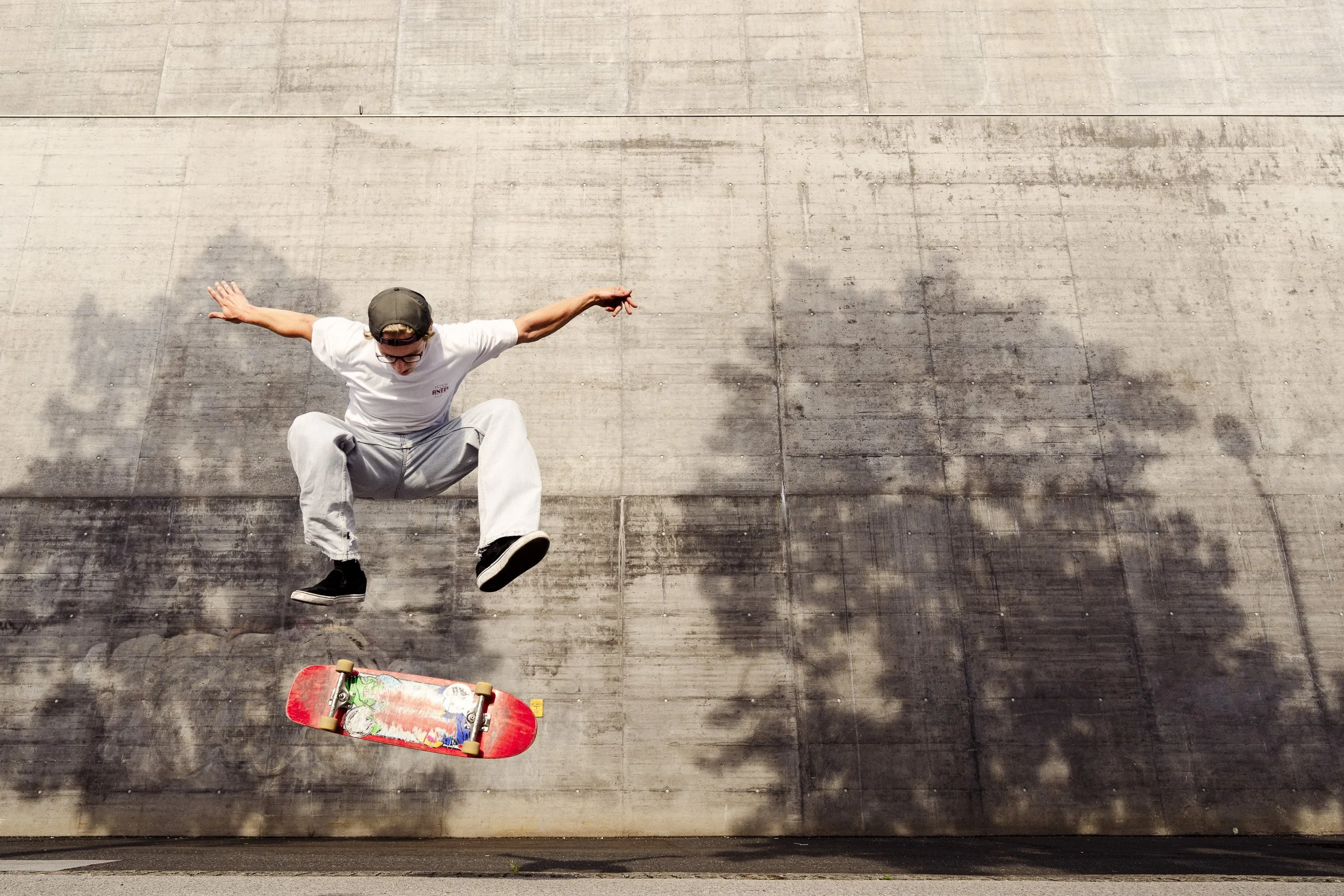 Skateboarder in mid-air performing trick on concrete surface