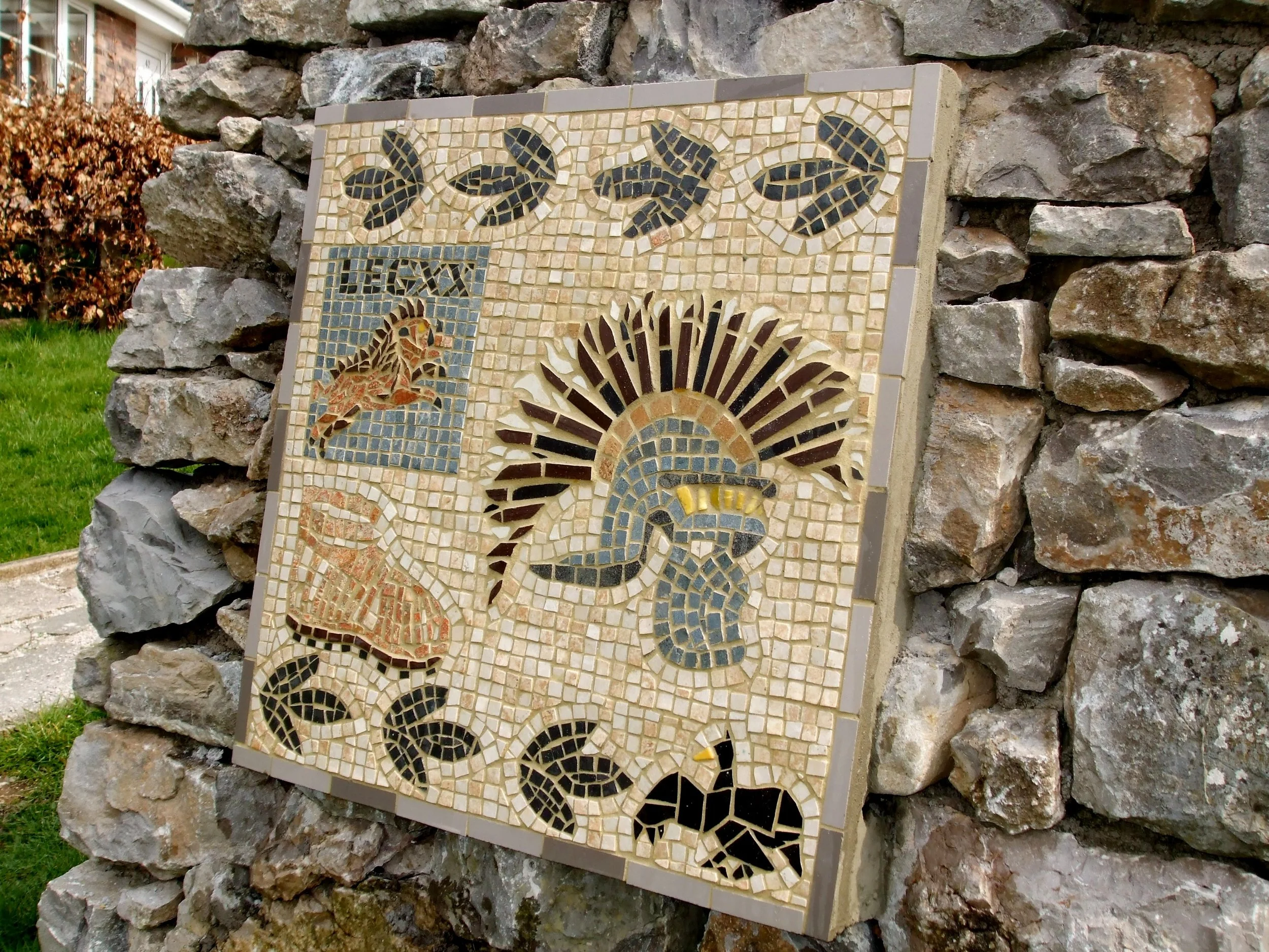 Prestatyn Roman Bathhouse, North Wales. Mosaic depicting symbols of the Roman 20th Legion stationed in Prestatyn. Part of the Merseyside Connections History Trail built in 2008 to celebrate Liverpool's Cultural Capital status. Granite, ceramic tile on a stone plinth. https://www.tripadvisor.co.uk/Attraction_Review-g551989-d8414355-Reviews-The_Roman_Bath_House-Prestatyn_Denbighshire_North_Wales_Wales.html
