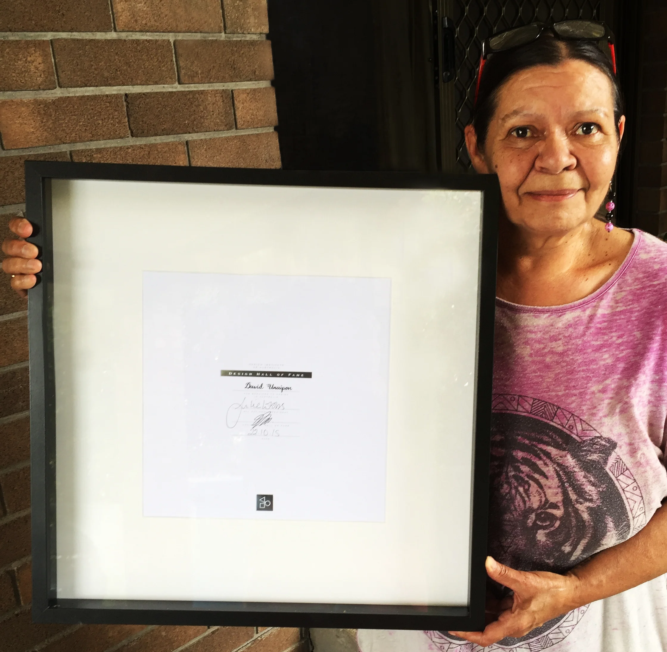 Elaine Kropinyeri holding her uncle David’s Design Hall of Fame certificate. 