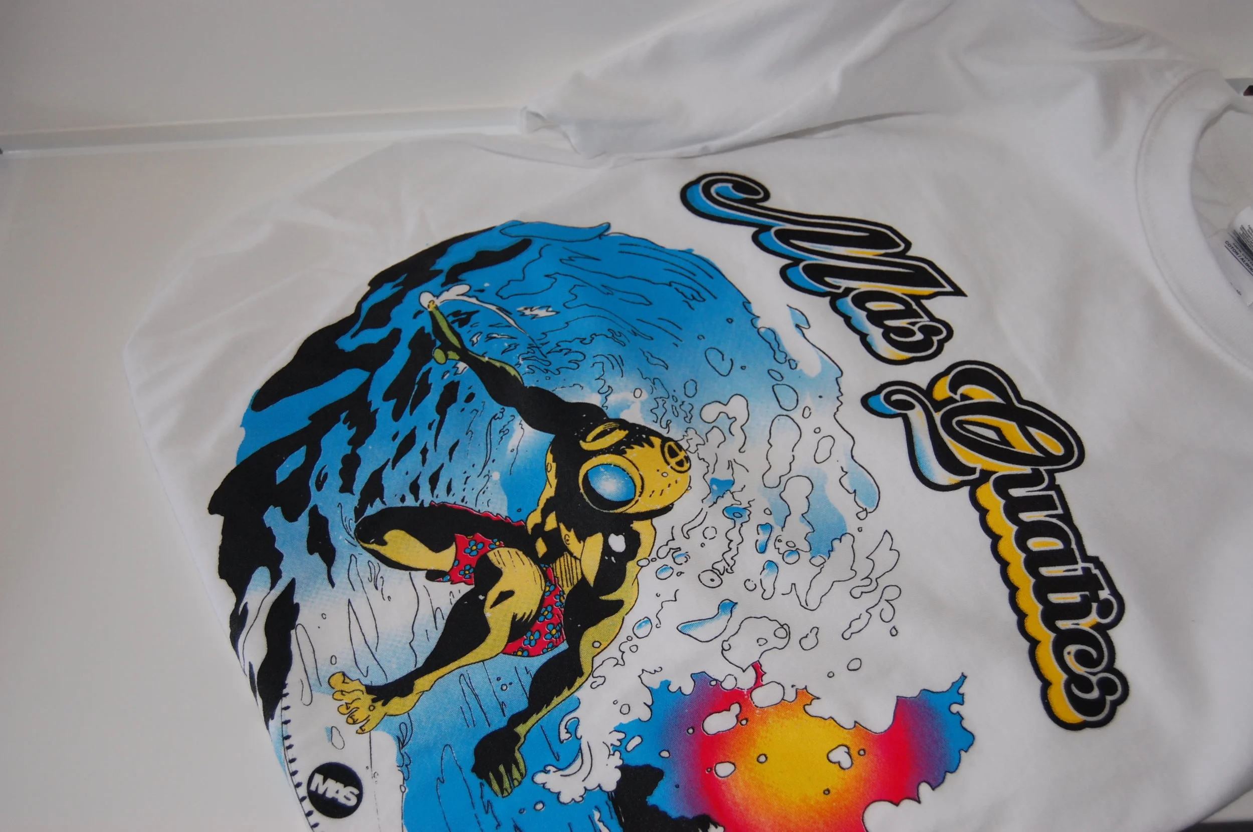 MASQUATICS SHIRT Our newest summer line "Mas Quatics". This print was achieved using halftone overlays. In the center of the design, the 2-tone character, the Diver Surfer, inspired by 80's and 90's surf art styles and the art of Jim Phillips, and R. Crumb. The design began with a hand drawn illustration, followed by a live trace to digitally render it, opting for a live trace rather than a digital recreation to preserve a hand-drawn feel. 
