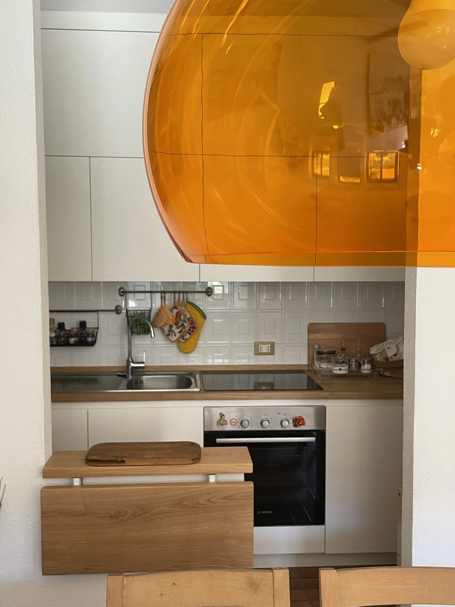  Per ampliare lo spazio di appoggio, vista la ridotta dimensione della cucina, è stato realizzato un piccolo ripiano a ribalta in rovere. 