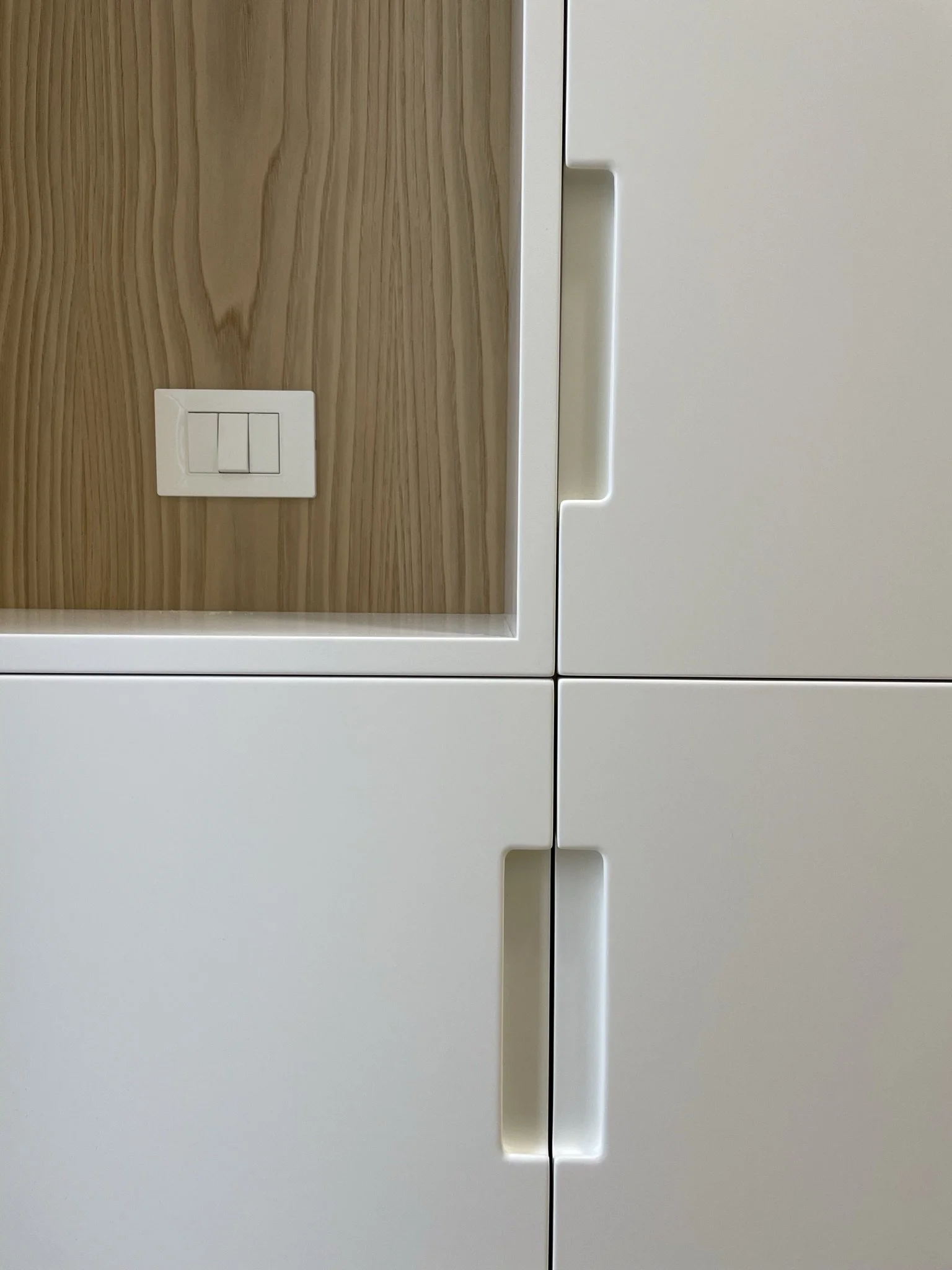  Il bianco opaco si sposa perfettamente con il legno naturale per il vano a giorno che funge anche da svuotatasche all’ingresso. 