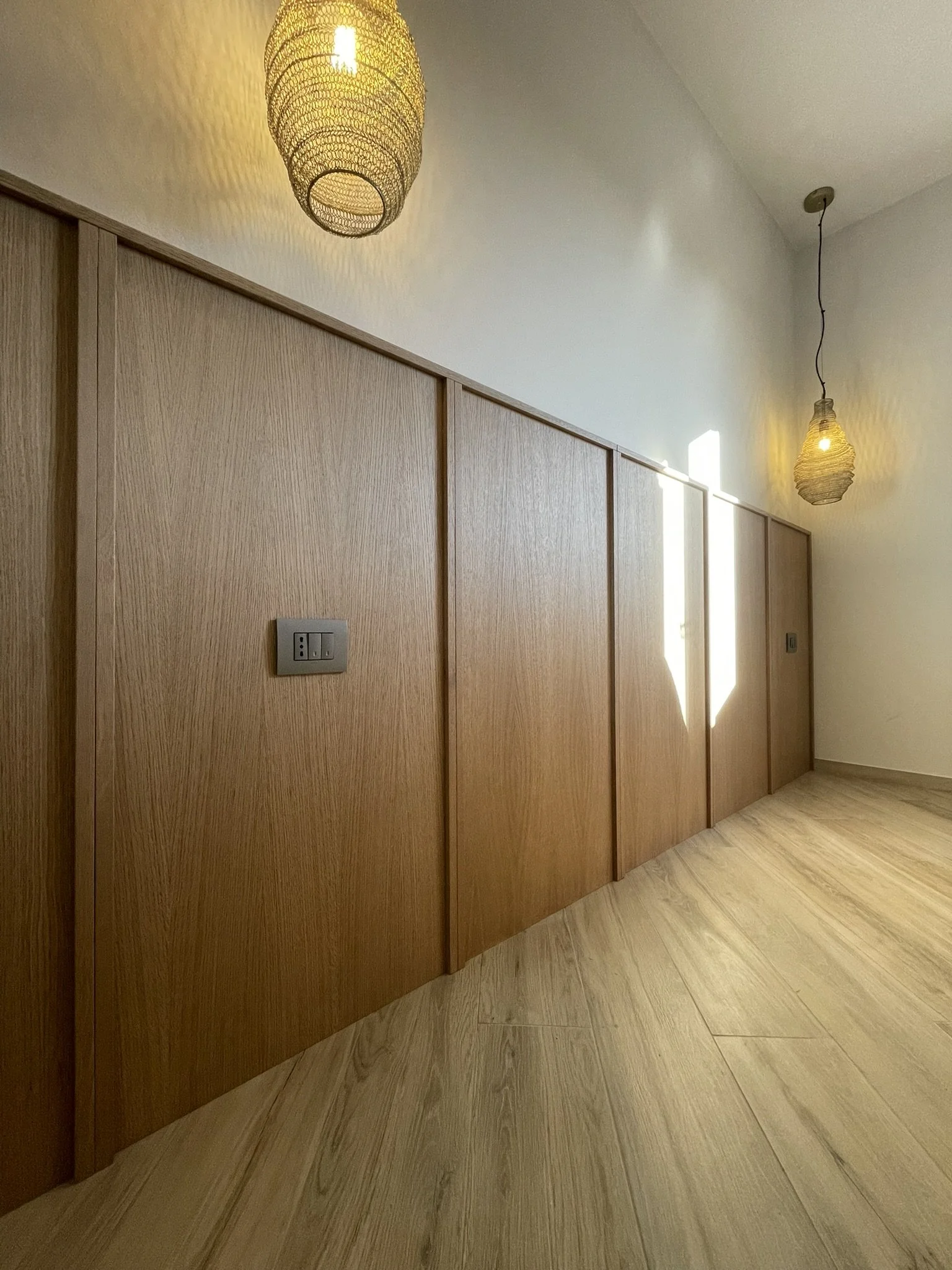  Boiserie realizzata con pannelli di listellare nobilitato rovere, fissati a muro tramite imbonaggio. 