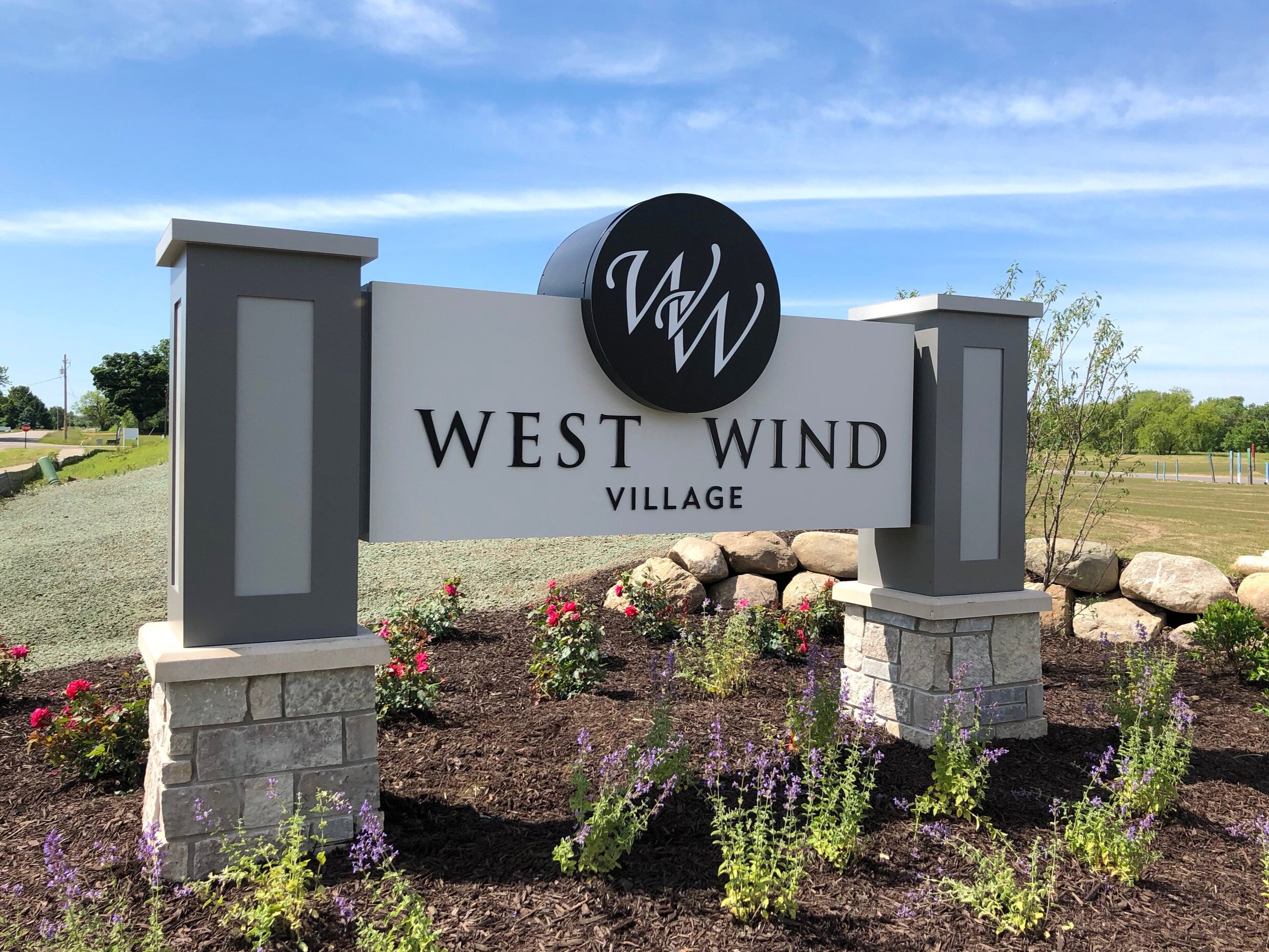  Monument sign with routed aluminum faces, push through acrylic lettering, stone columns and custom aluminum columns and a circular logo. 
