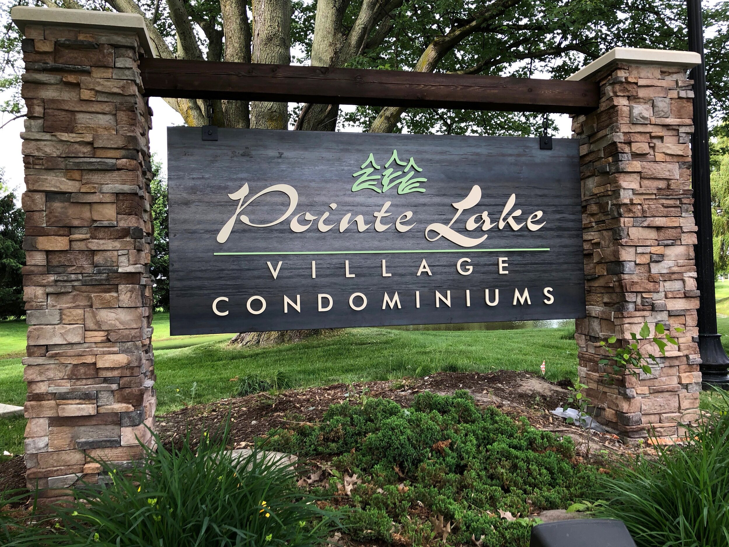  Monuement sign with Corten steel panel, dimensional lettering and stone columns. 