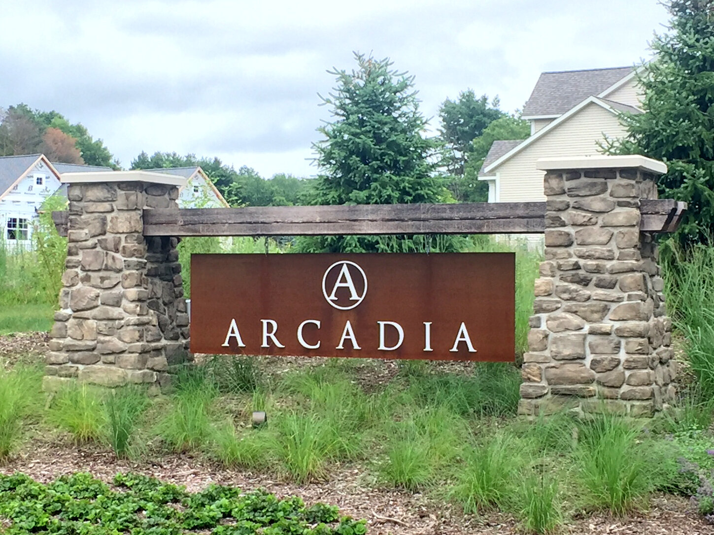  Monument sign with Corten steel plate, dimensional lettering, wood beam and stone columns. 