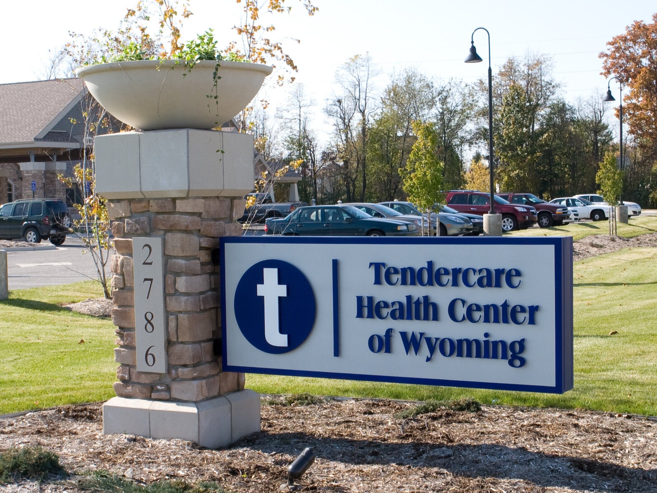  Flagmount monument sign with aluminum construction and dimensional lettering with a masonry column with planter. 