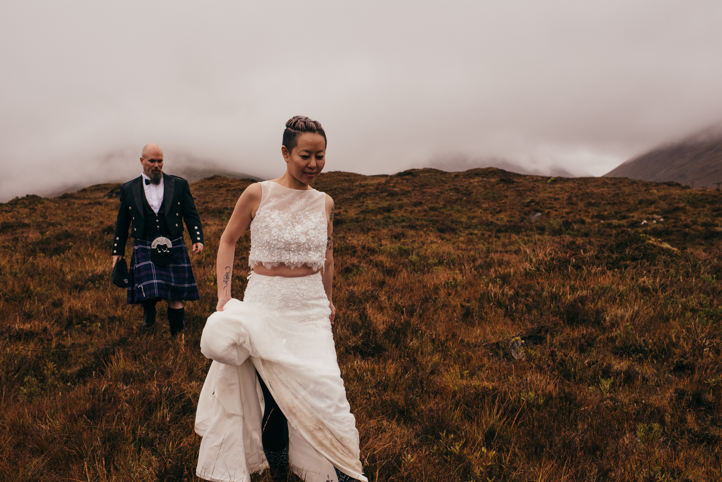 Bride and groom hiking through wilderness