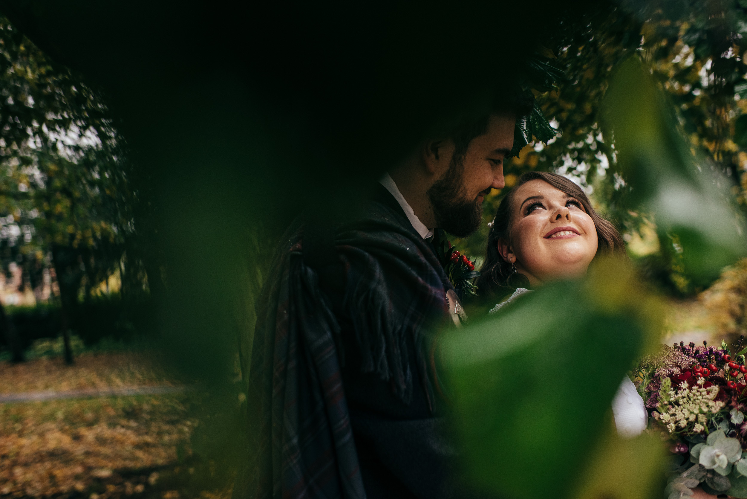Bride and groom framed by leaves