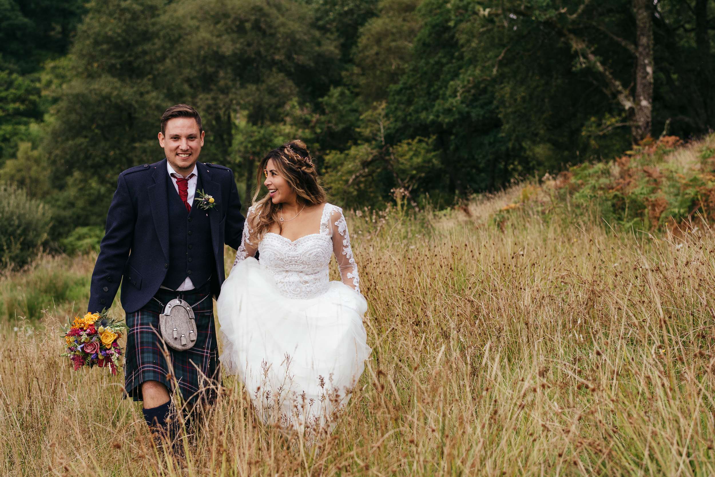Bride and groom walking in a field