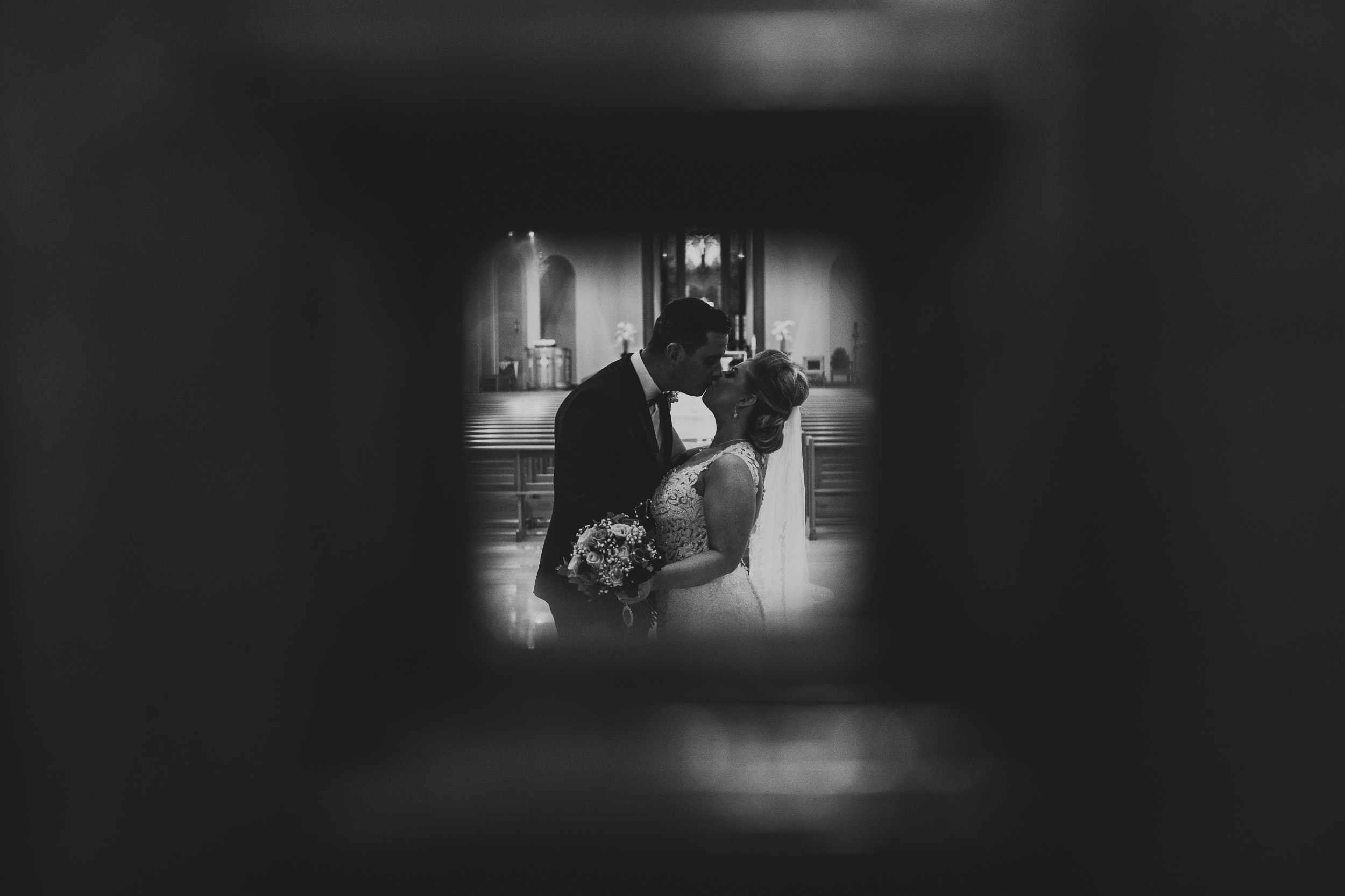 Creative wedding portrait through small window