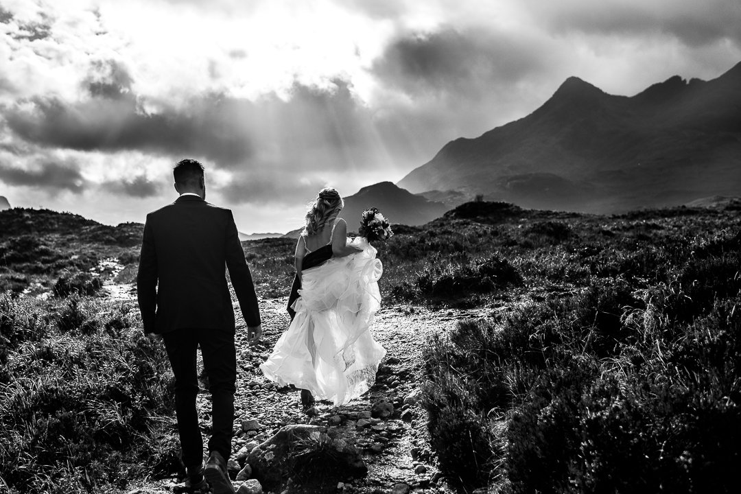 Bride and groom walking into mountains