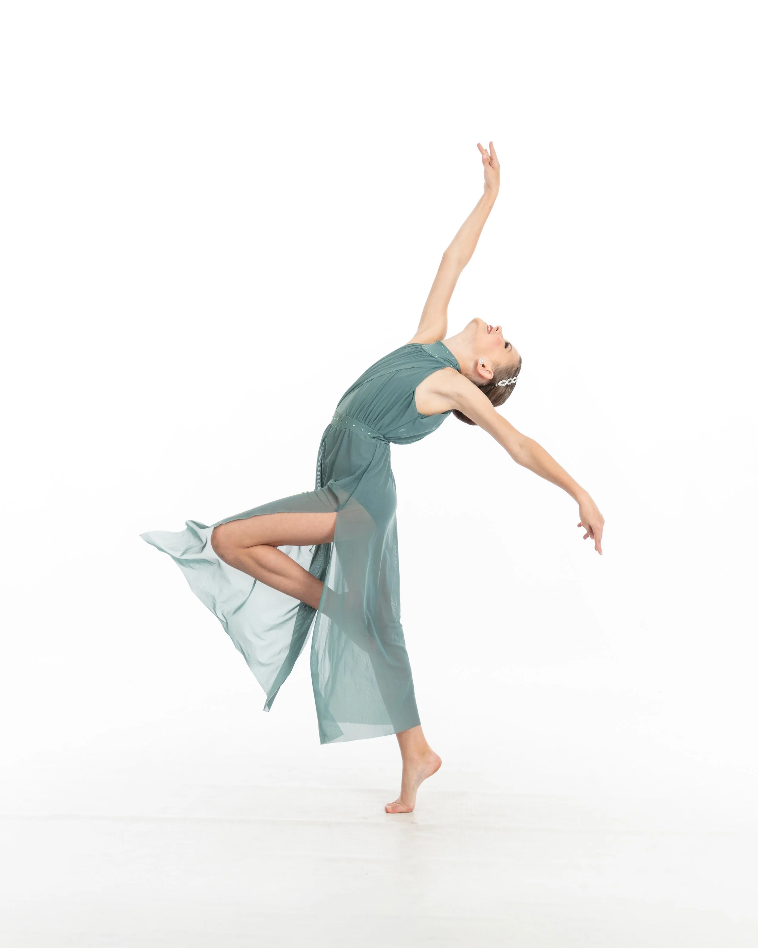 A female dancer in a flowing dress performing a contemporary dance move against a white background.