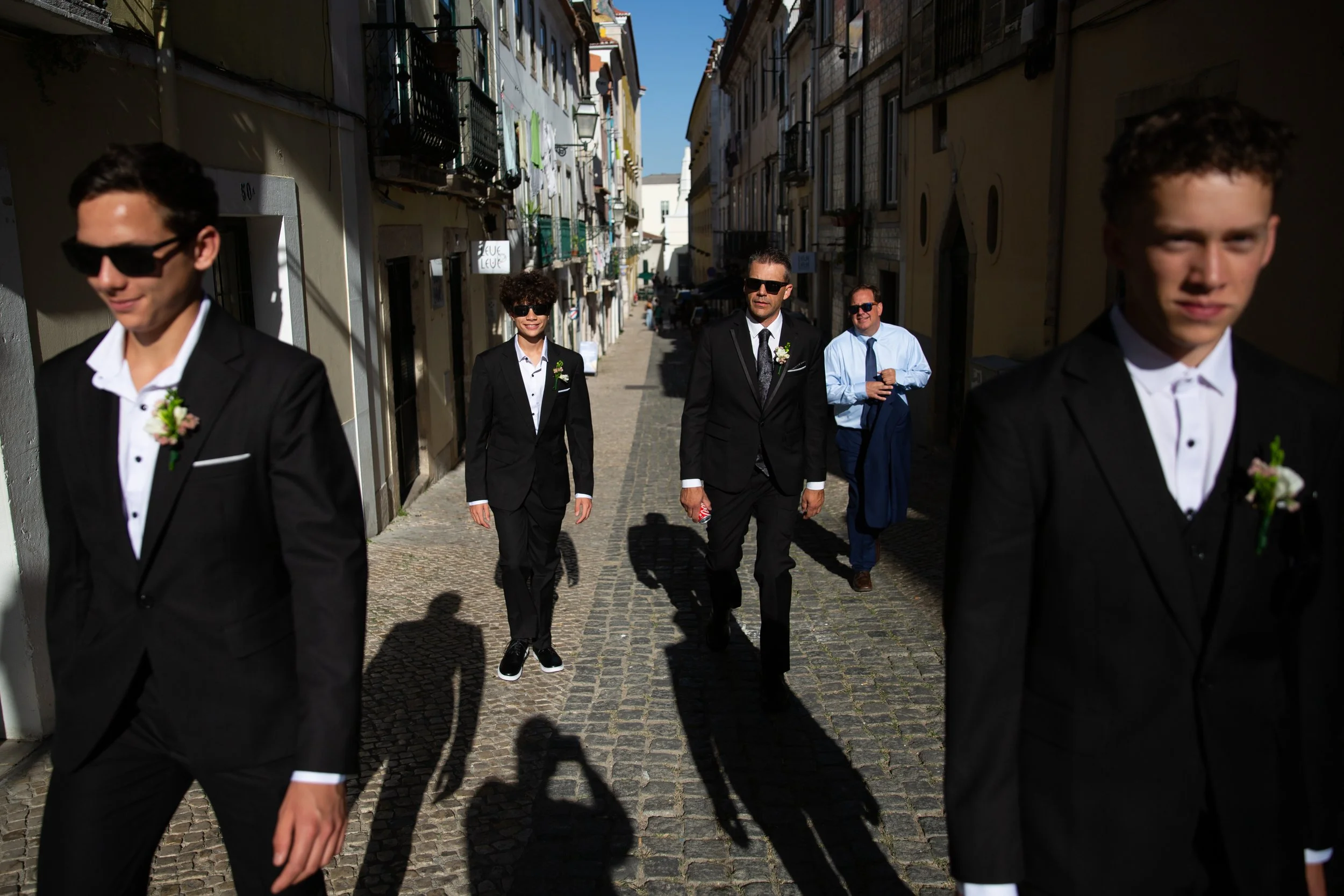 Groom with his sons walking on a street in Lisbon during their wedding day.