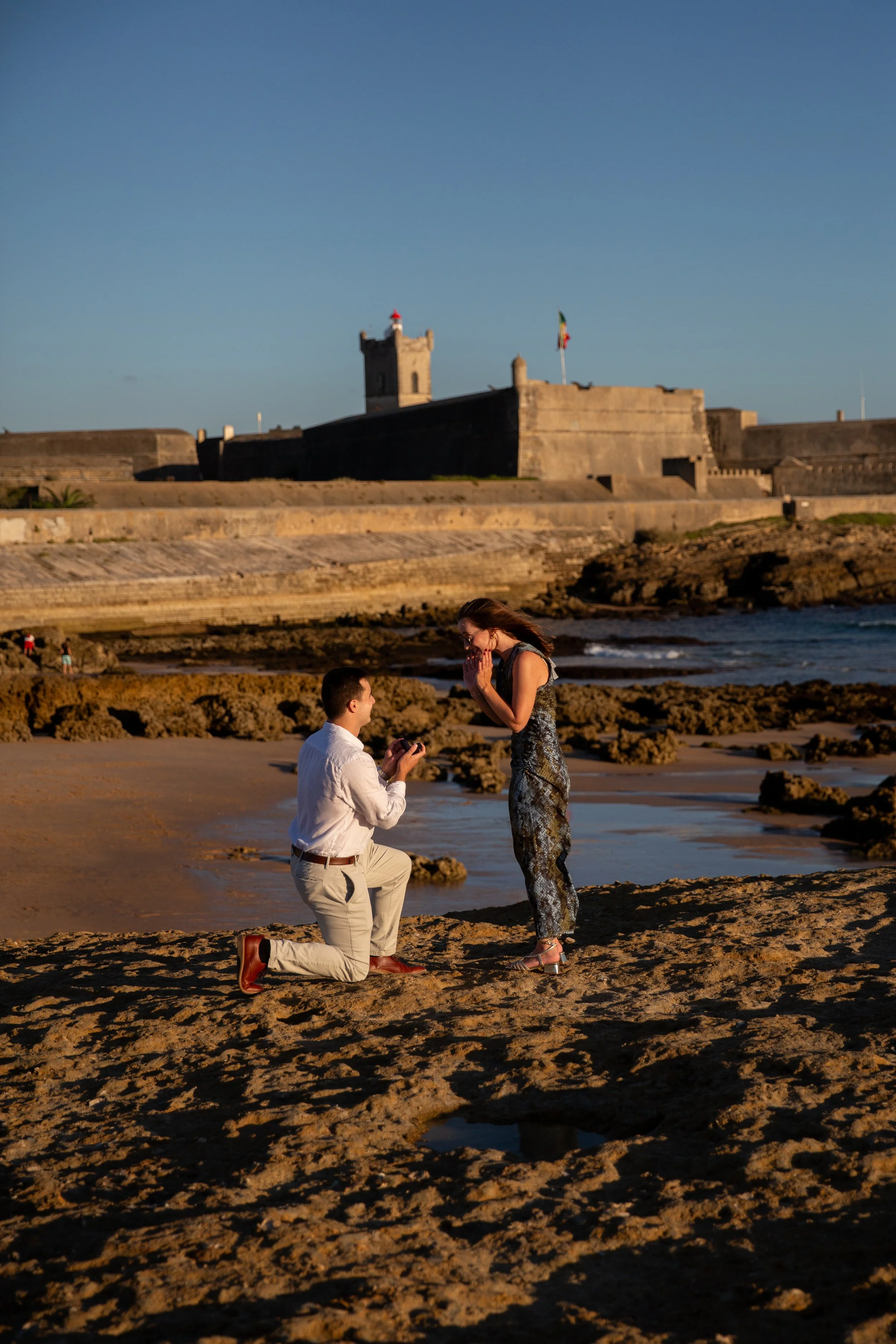 Romantic Oeiras beach proposal at Praia do Moinho during sunset.