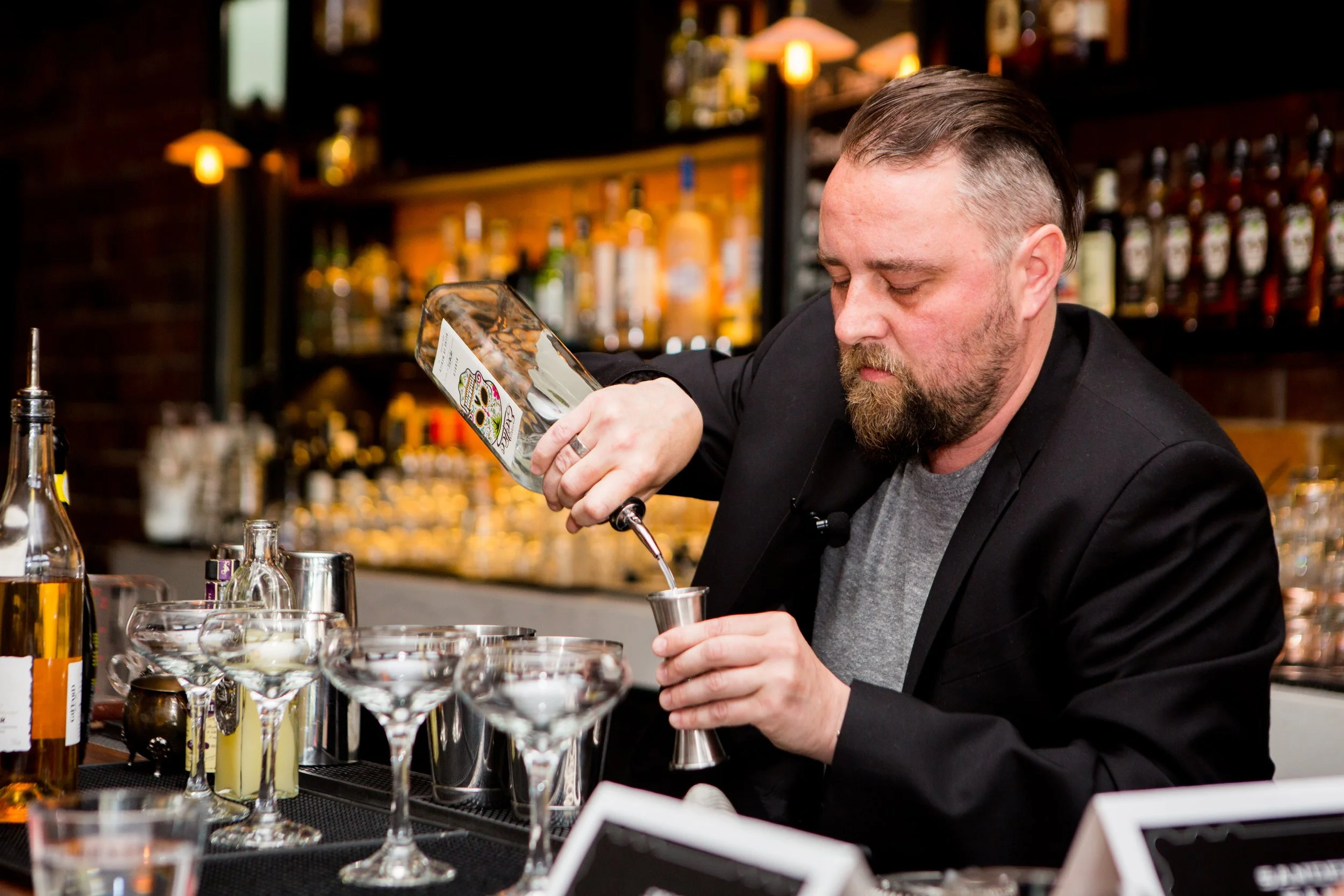 Professional cocktail event photography in Lisbon, Portugal, capturing the branded content of the event host, Exotico Tequila while a bartender competitor makes a cocktail with it. 