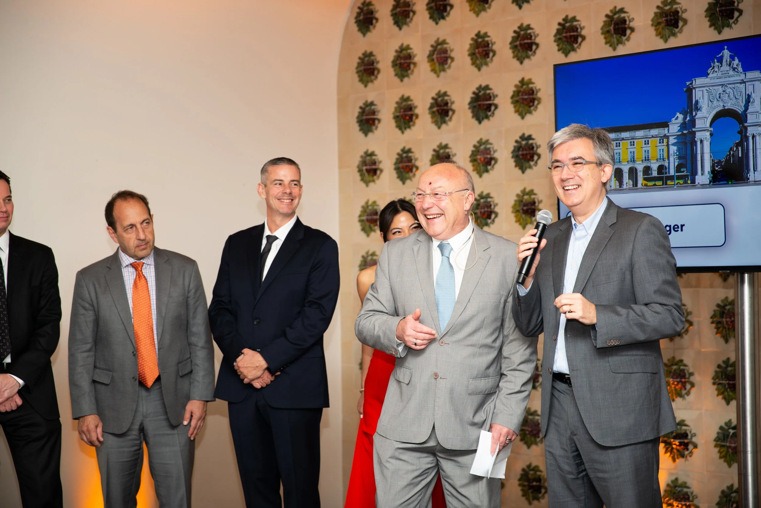Candid photo at a Lisbon corporate event, during an awards ceremony with a speaker on stage speaking about a person at the company.