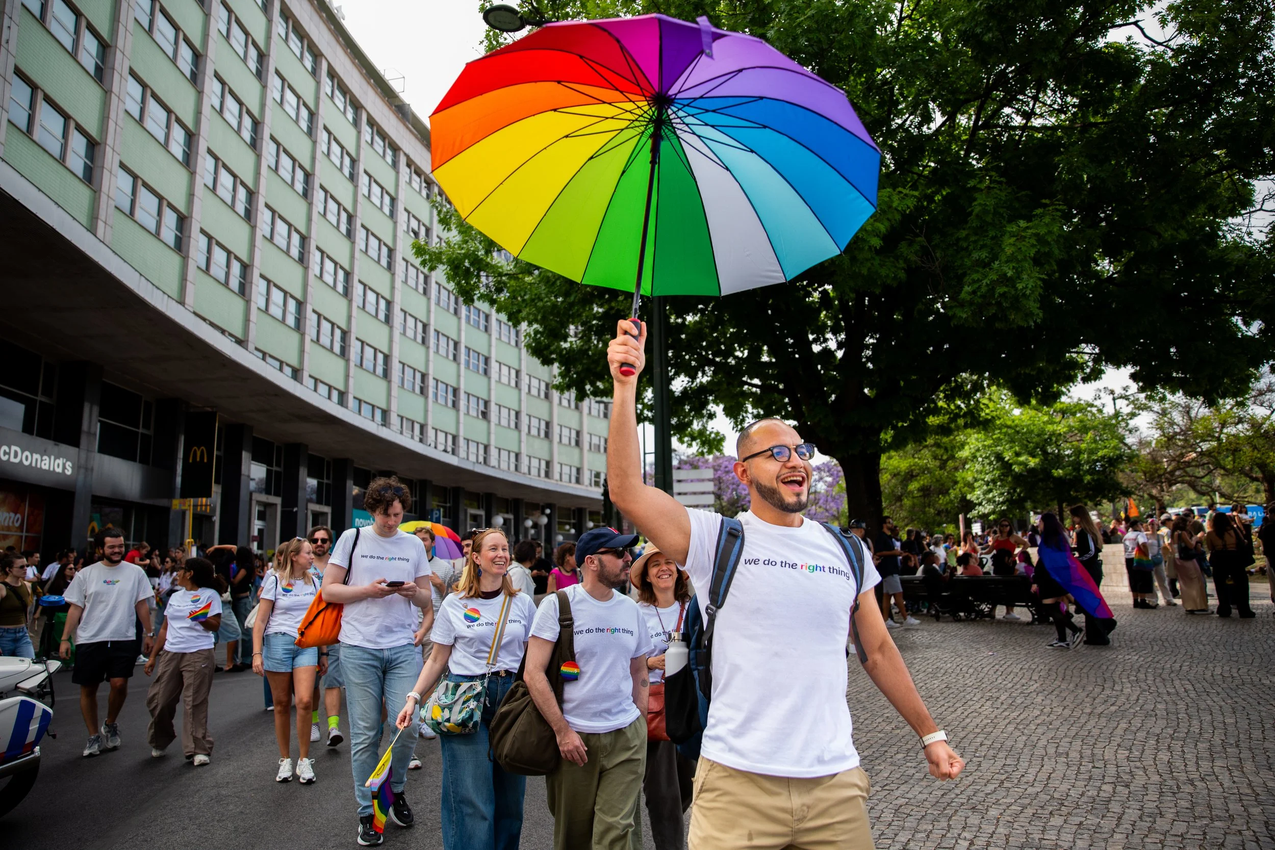 Professional event photography in Lisbon, Portugal, capturing a corporate group participating in a Pride parade in support of LGBTQ+ rights and equality. This image highlights community, visibility, allyship, and the importance of businesses standing