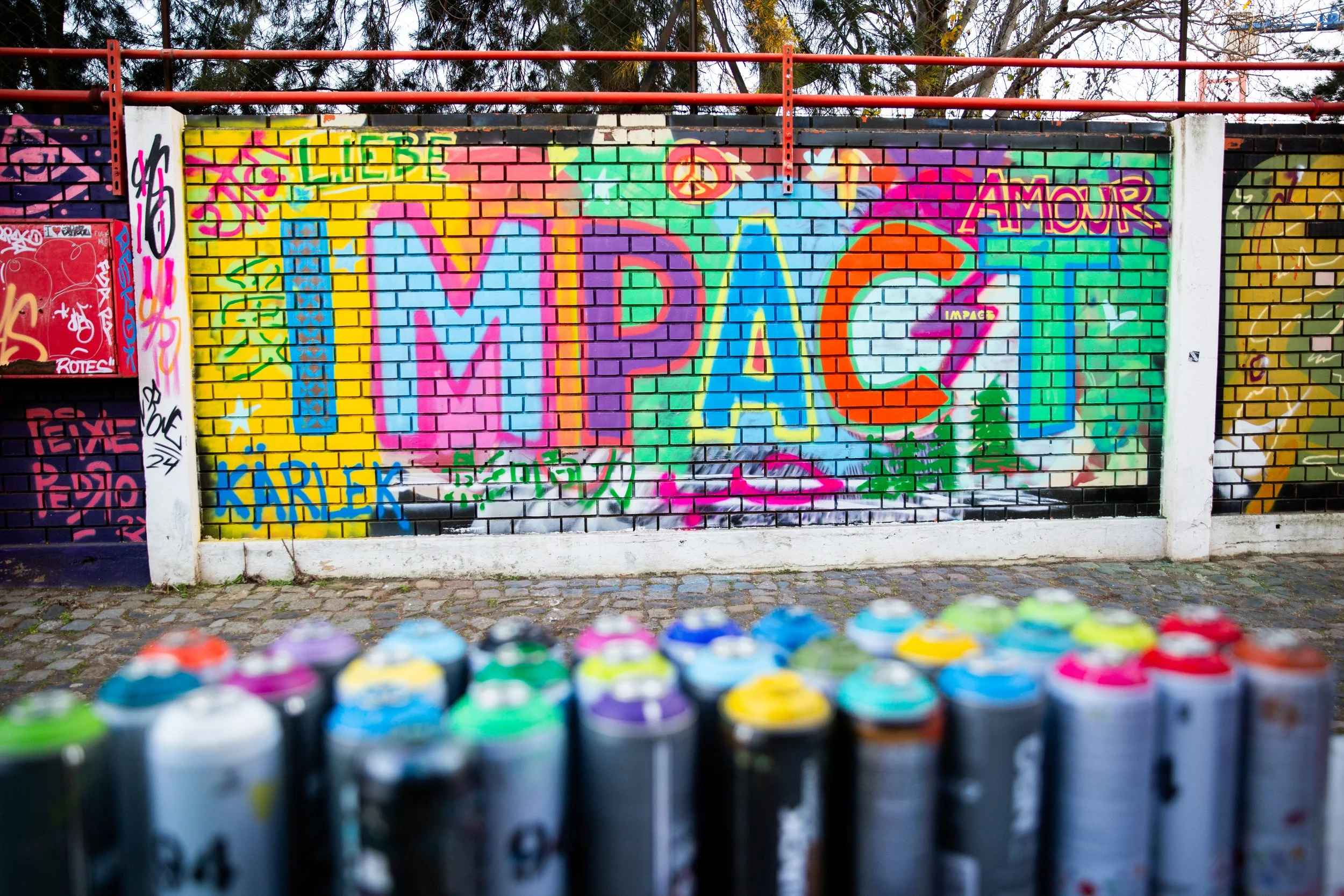 Corporate team-building photography in Lisbon, Portugal, capturing employees learning graffiti art during a creative workshop designed to encourage collaboration, creativity, and team connection.