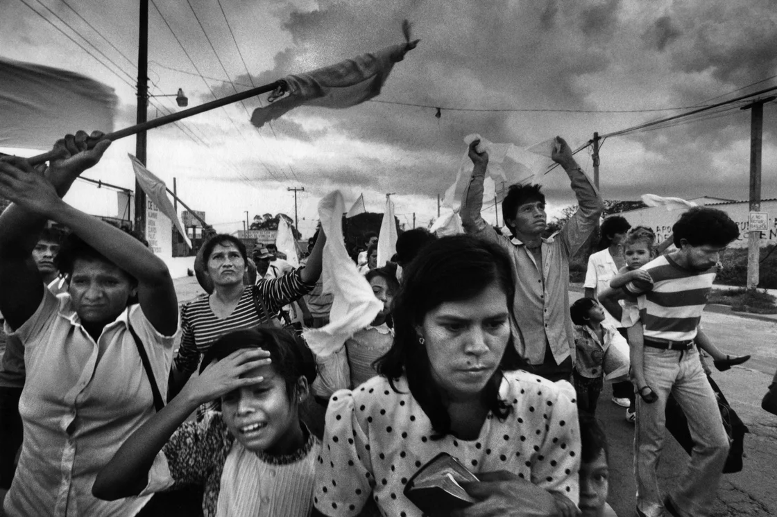 In November 1989, civilians in a zone held by insurgents flee their working-class barrio after three days of aerial bombing by the Salvadoran air force in Soyapango, El Salvador. Photo by Donna DeCesare.