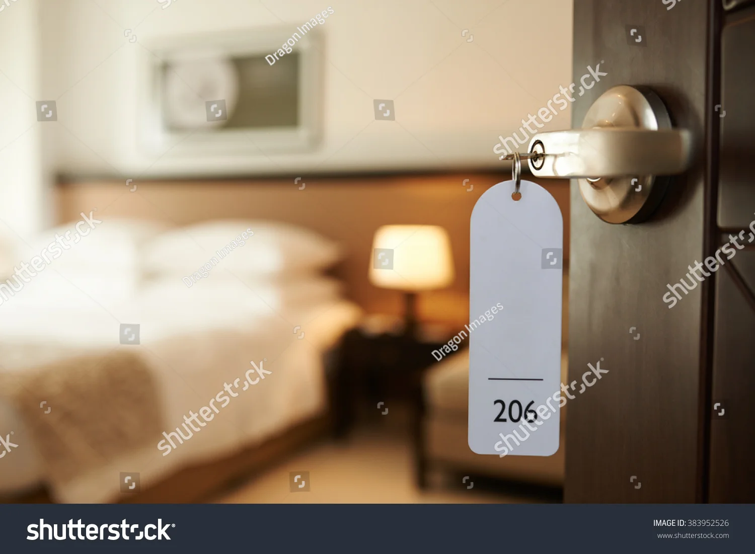 stock-photo-opened-door-of-hotel-room-with-key-in-the-lock-383952526.jpg