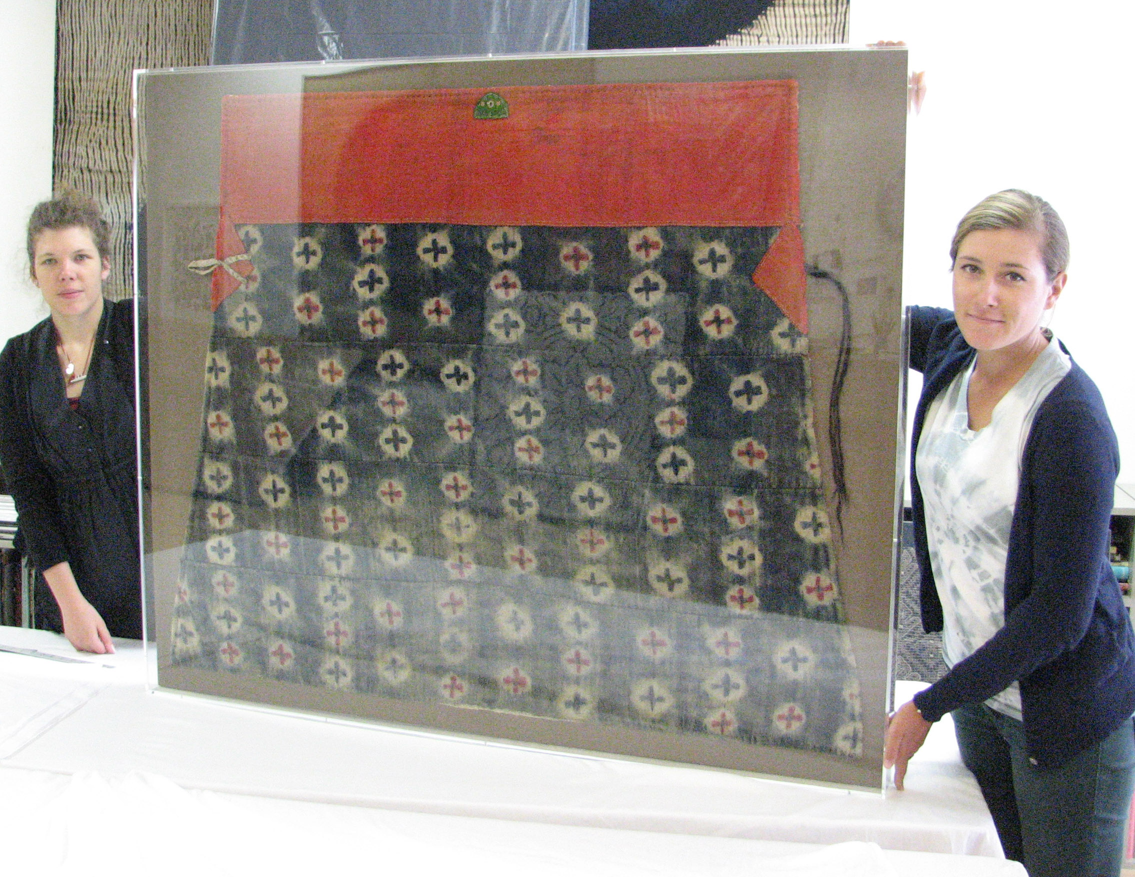  Tibetan textile mounted on linen and encased in acrylic frame.    