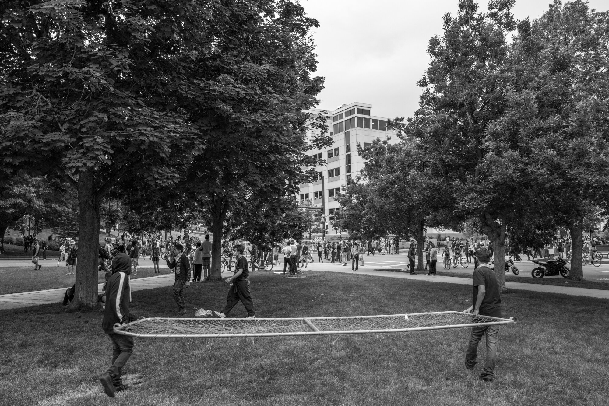 Two protesters carry part of a fence to help construct it. 5/30/2020.