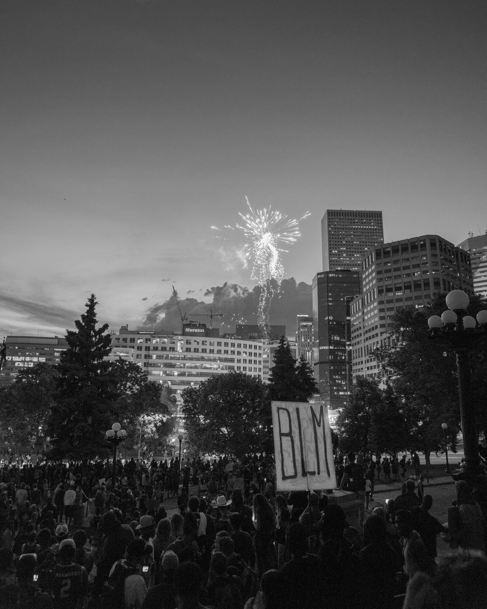 A firework lights up the sky behind the protesters. 6/02/2020.