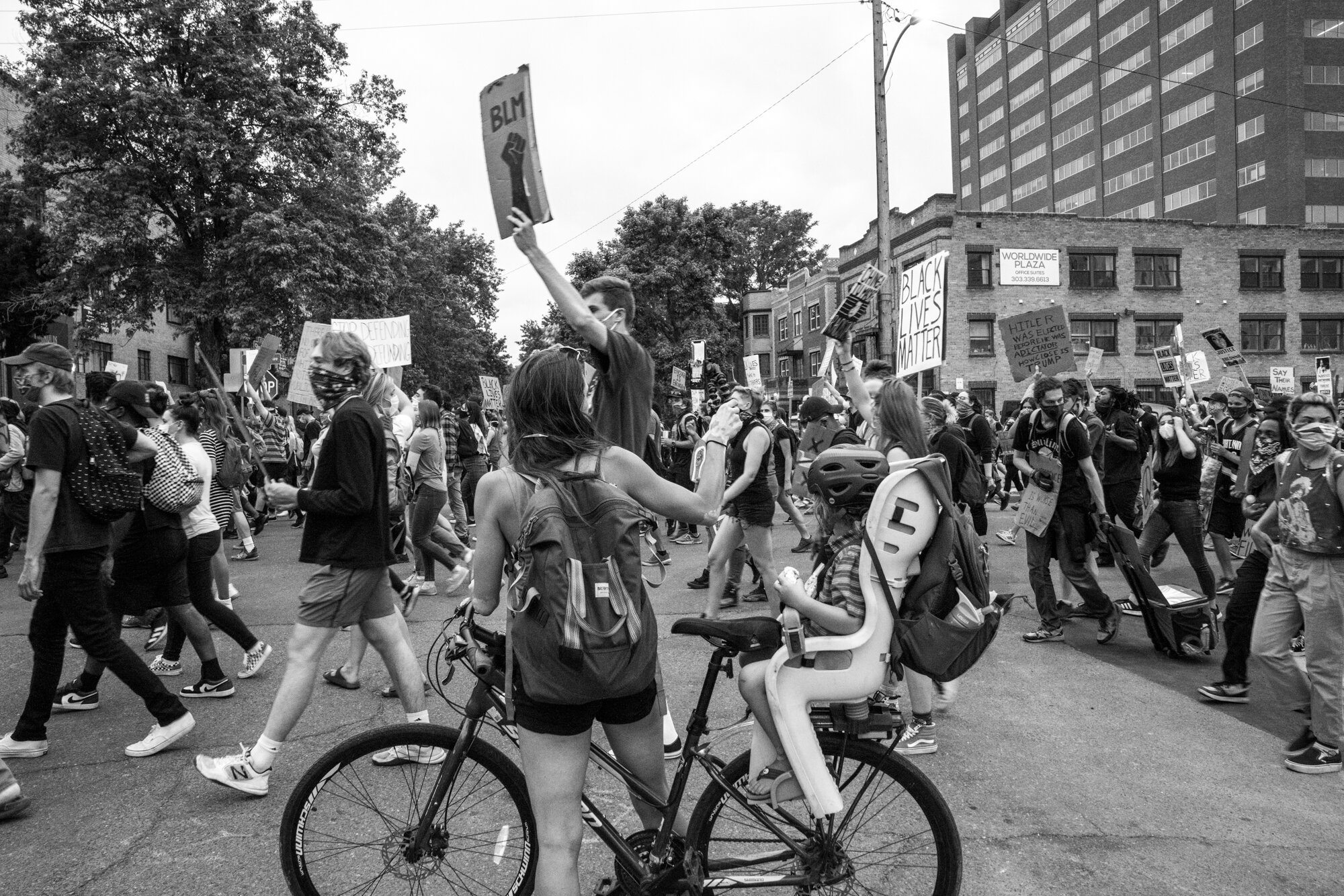 A woman and her child watch the march from their bike. 6/02/2020.