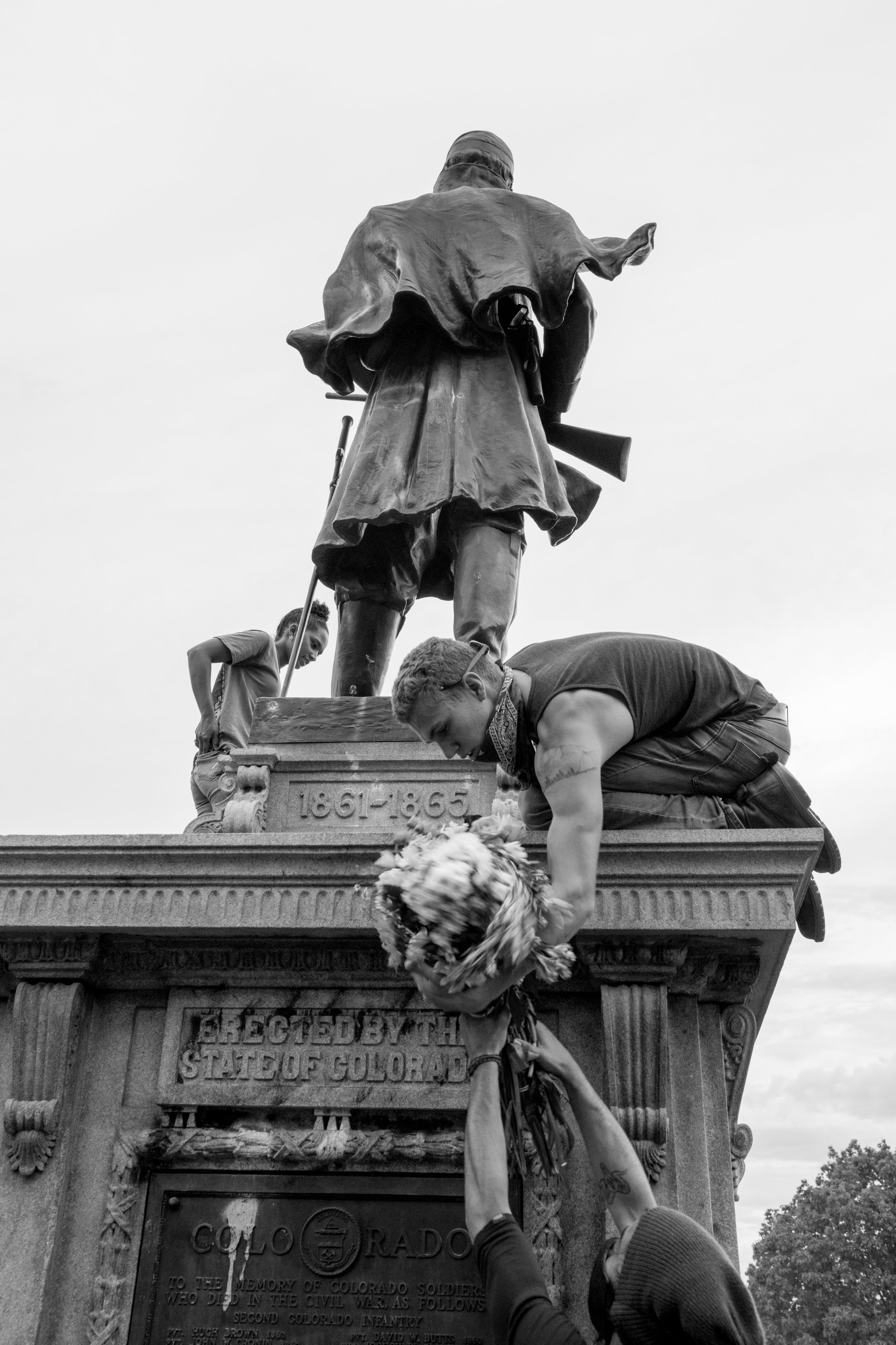 A protester hands another a bouquet of flowers. 6/01/2020/