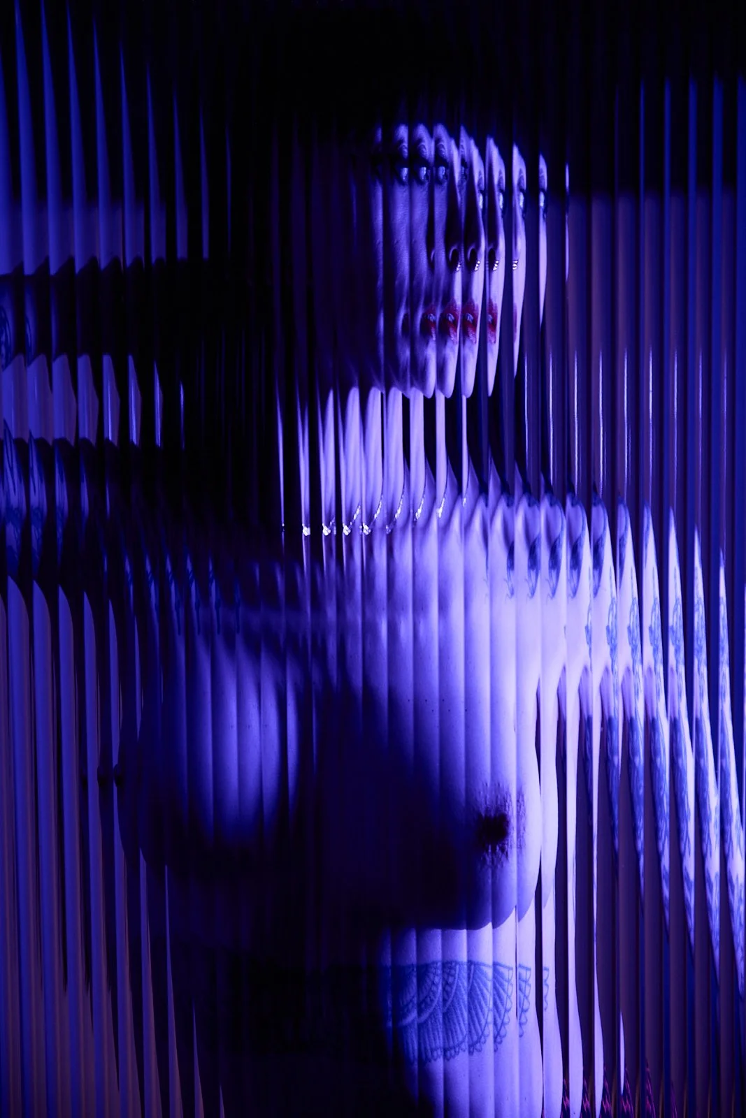 Ramona Ryder is standing behind distorted glass wearing lingerie.