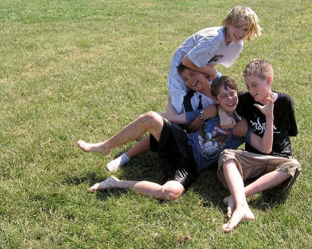 Notice everyone's smiles. Even the boy on the bottom, who looks like is getting tackled by the boy in the white. 