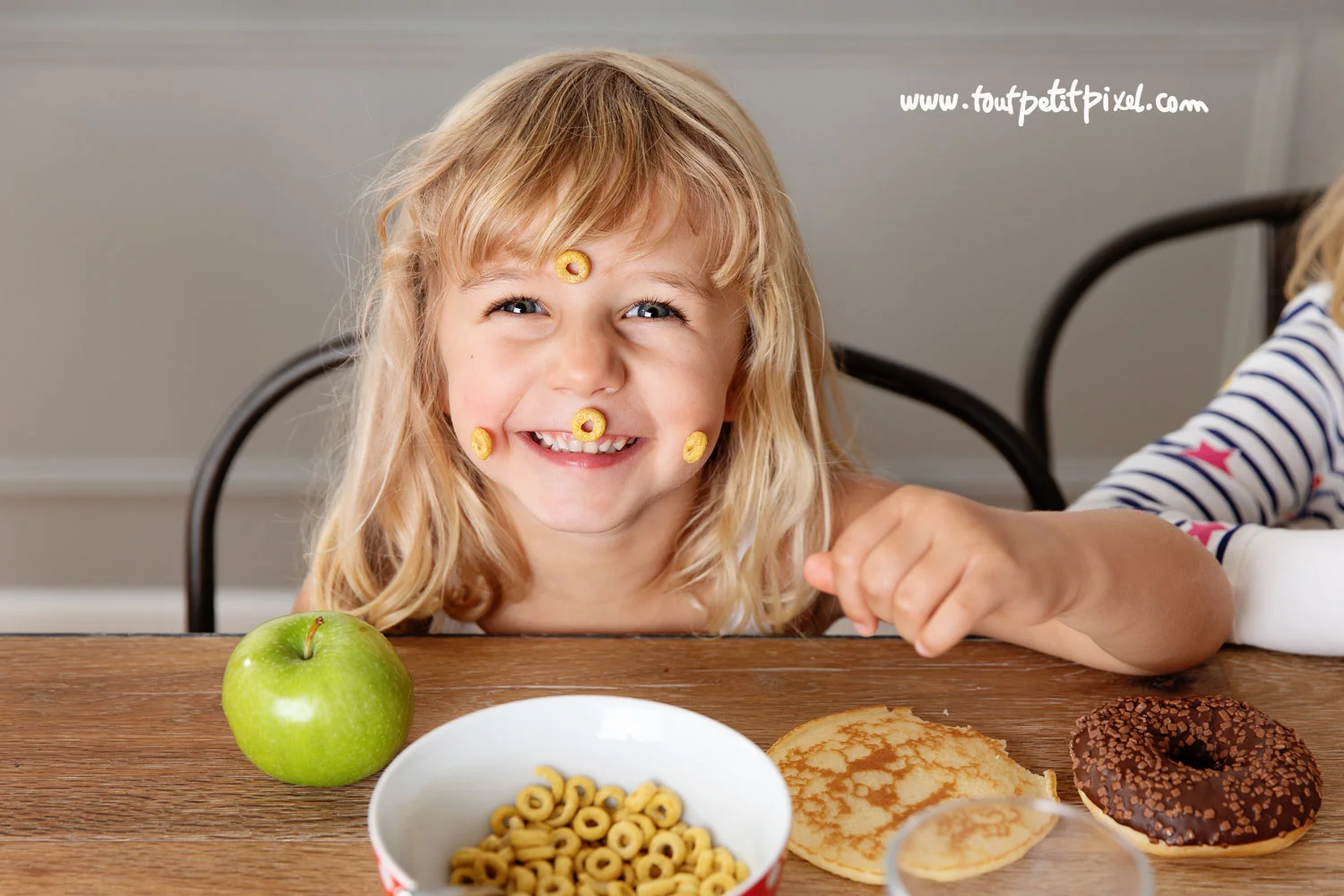Petites-filles-qui-sourit-avec-des-cereales-collees-sur-le-visage.jpg