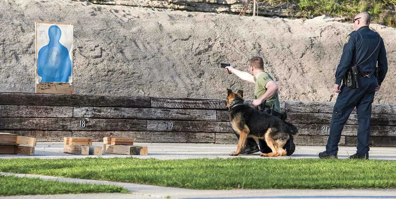 Lexington’s Canine Unit conducts large trainings once a month to expose handlers and canines to situations they may not encounter every day. Here, K-9 Officer Jack Hoskins practices shooting and reloading single handedly while maintaining control of his K-9, Destro. Destro also is learning to develop a neutral reaction to live gunfire. (Photo by Jim Robertson)