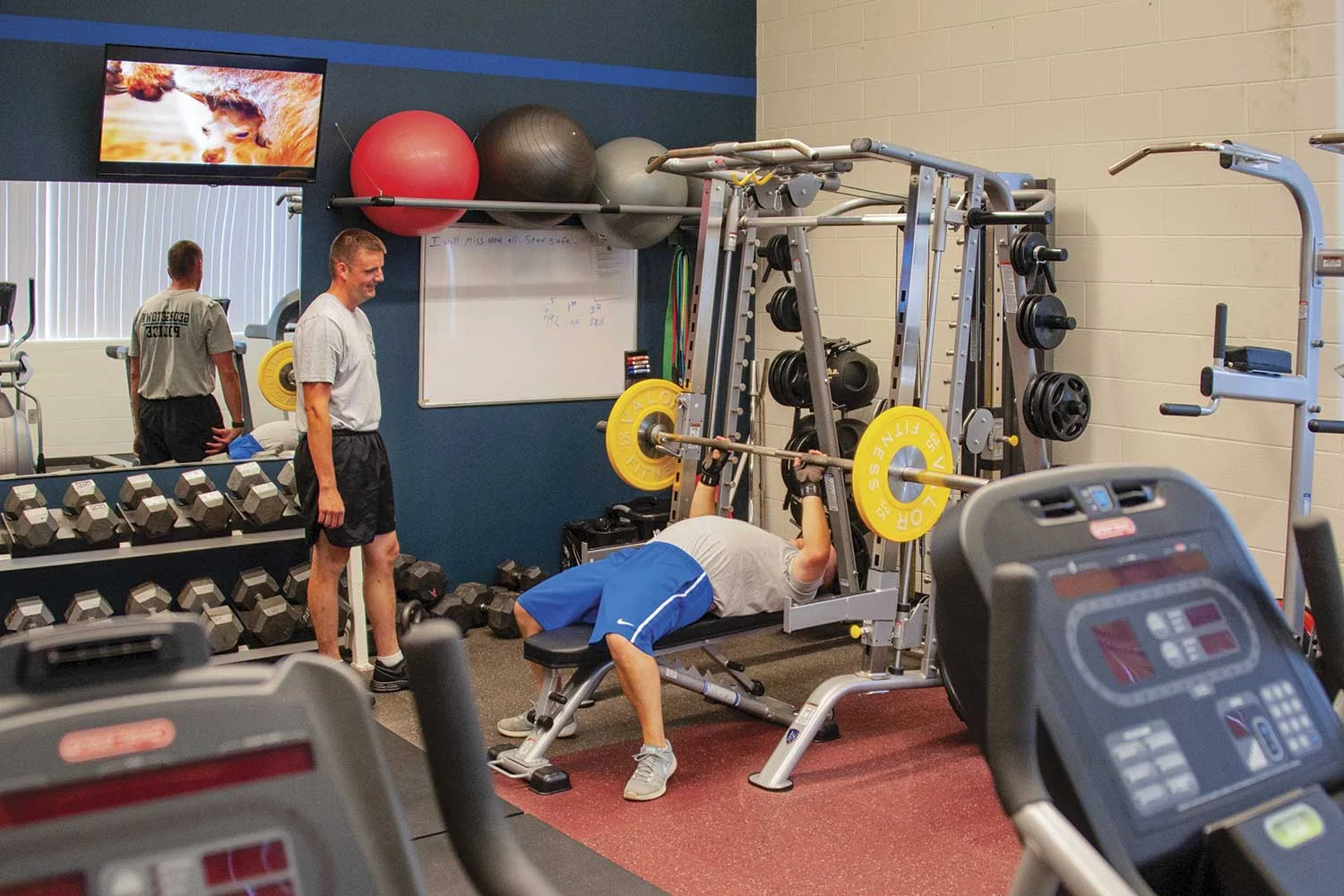 Georgetown Police Detective Lewis Crump, standing, and GPD Sgt. Jason Bruner take advantage of the police department’s in-house fitness facility. GPD Chief Mike Bosse said the gym equipment was obtained for free via military surplus and a donation from the Citizens’ Police Academy. (Photo by Jim Robertson)