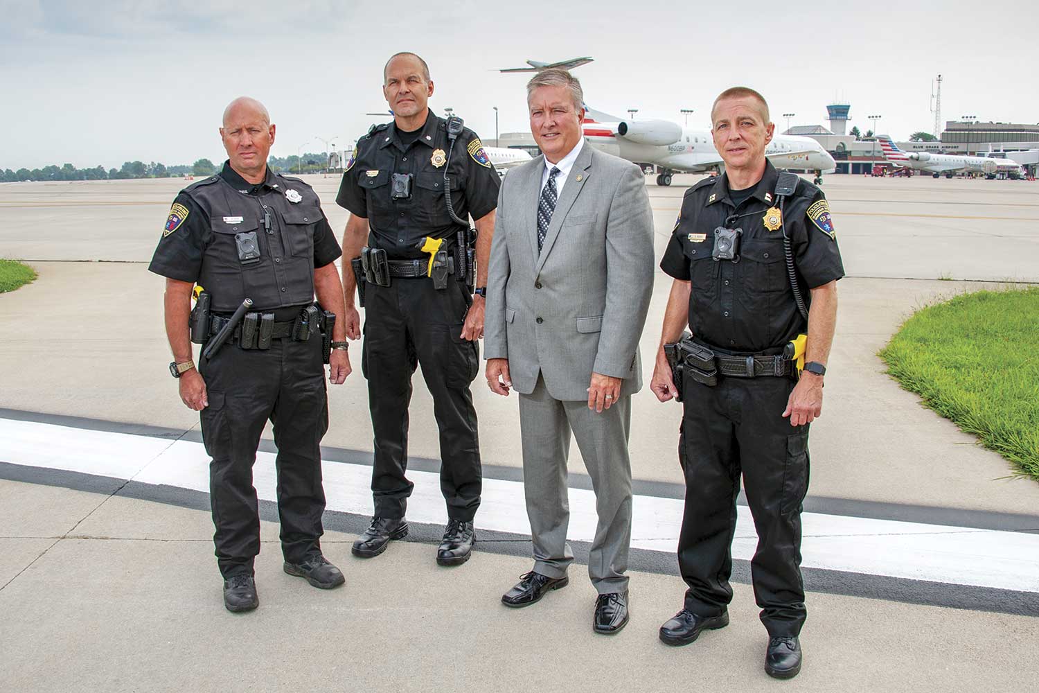  From left-to-right, Blue Grass Airport Public Safety Officer Ken Ridge, Assistant Chief Paul Pungratz, Pubic Safety Director Scott Lanter and Capt. Keith Moore pose on the flight line outside the public safety facility. (Photo by Jim Robertson) 