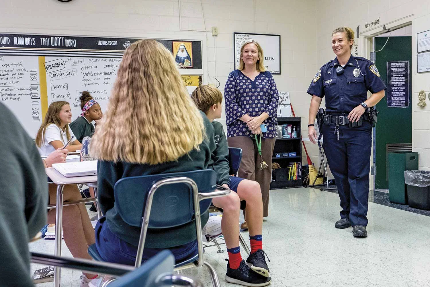 Owensboro Police Officer Jennifer Haynes, right, greets students at Owensboro Catholic Middle School alongside Principal Sara Guth. Haynes serves OCMS as part of Owensboro Police Department’s adopt-a-school program. (Photo by Jim Robertson)
