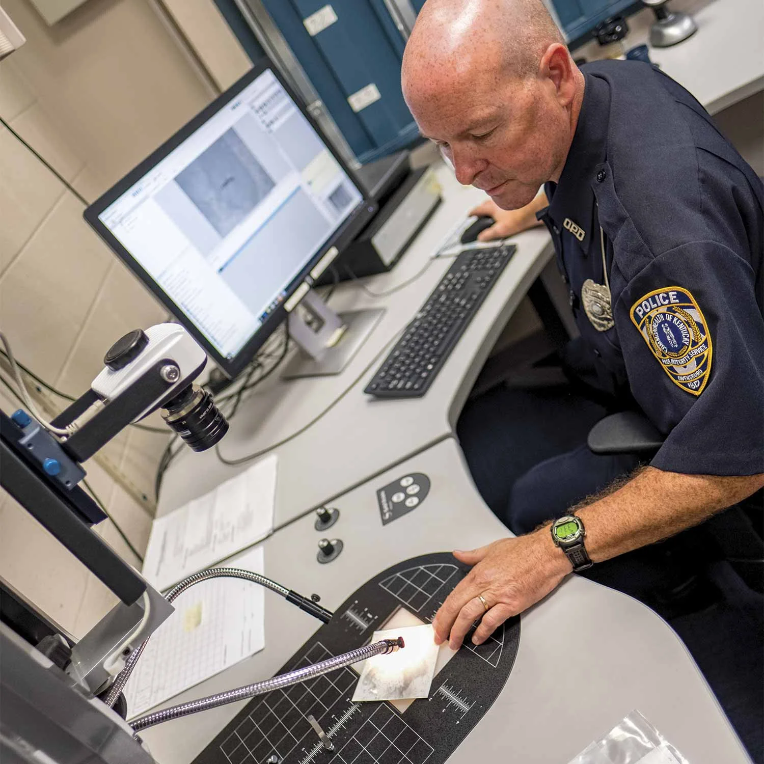 Owensboro Police Officer Jim Parham processes evidence using the department’s Automatic Fingerprint Identification System, better known as AFIS. (Photo by Jim Robertson)