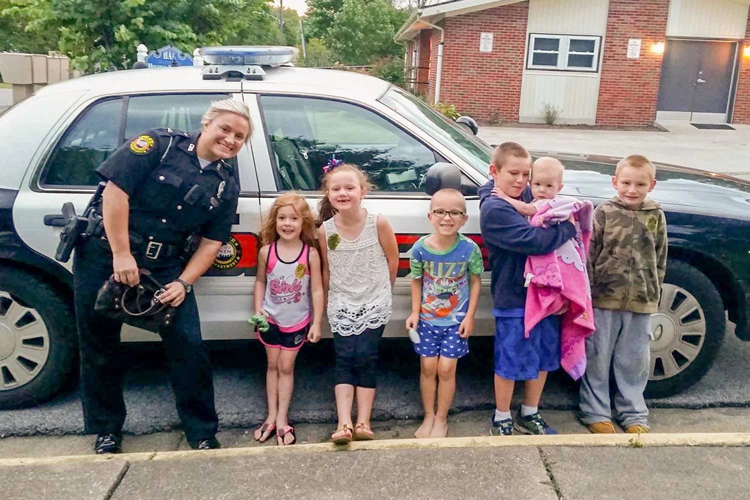 London Police Officer Ashley Taylor poses with several kids from the community she serves. The LPD officer said it’s not uncommon for her to pull her cruiser over, get out and interact with children. (Photo provided)