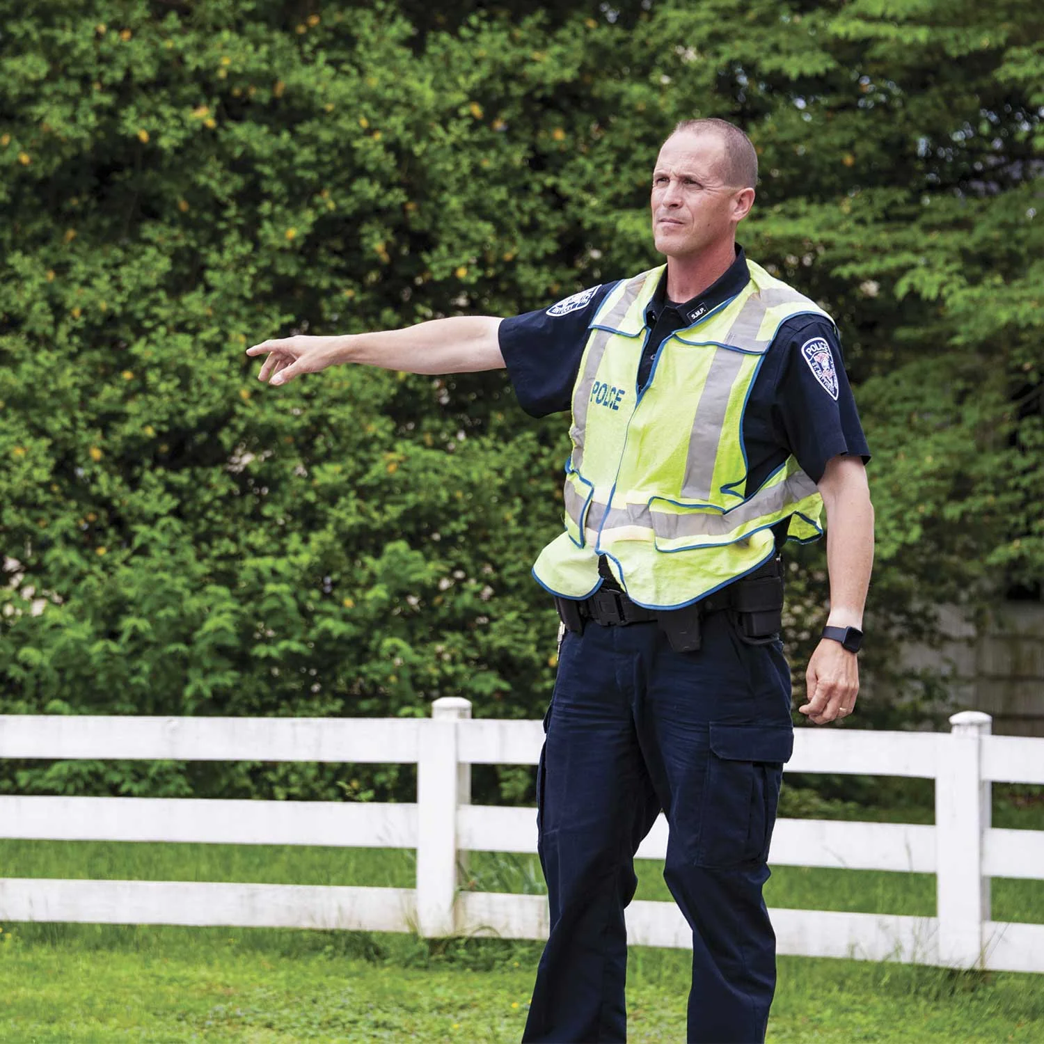 Officer Troy Armstrong directing traffic at the end of a school day. Armstrong said he tries to show students that not every interaction with police is going to be negative, so they can see officers as people. (Photo by Jim Robertson)