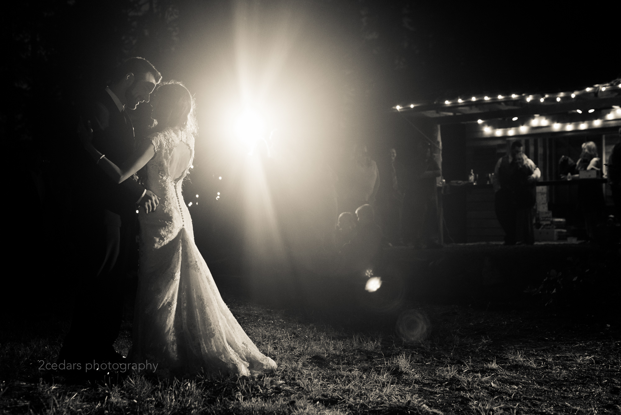 Bride and groom dancing at an outdoor Puget Sound wedding with backlight in black and white