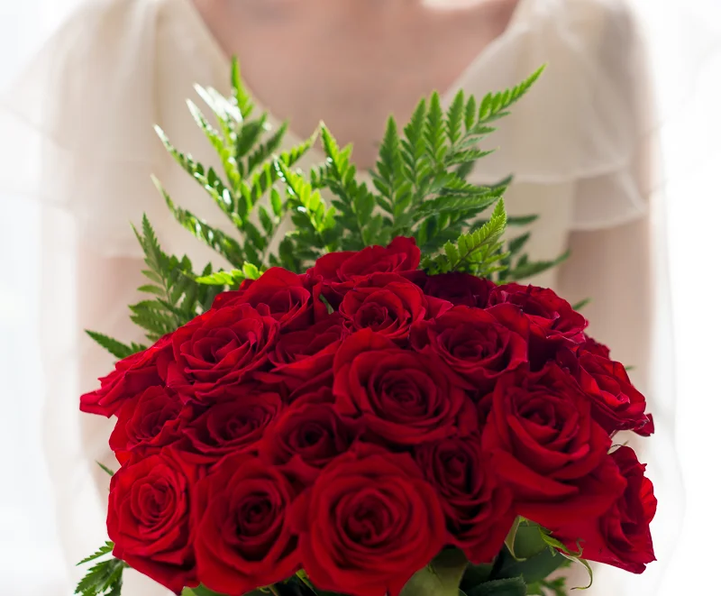Bride red rose bouquet detail portrait in window light