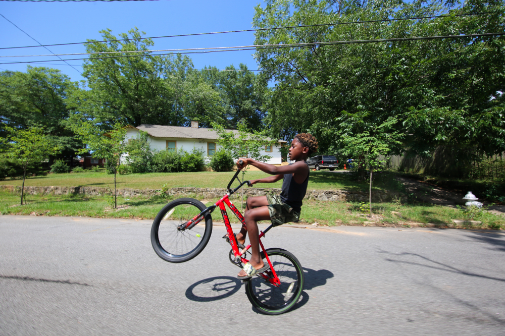 ABOVE: Derrick McLemore, 10, practices “walking” his bike.